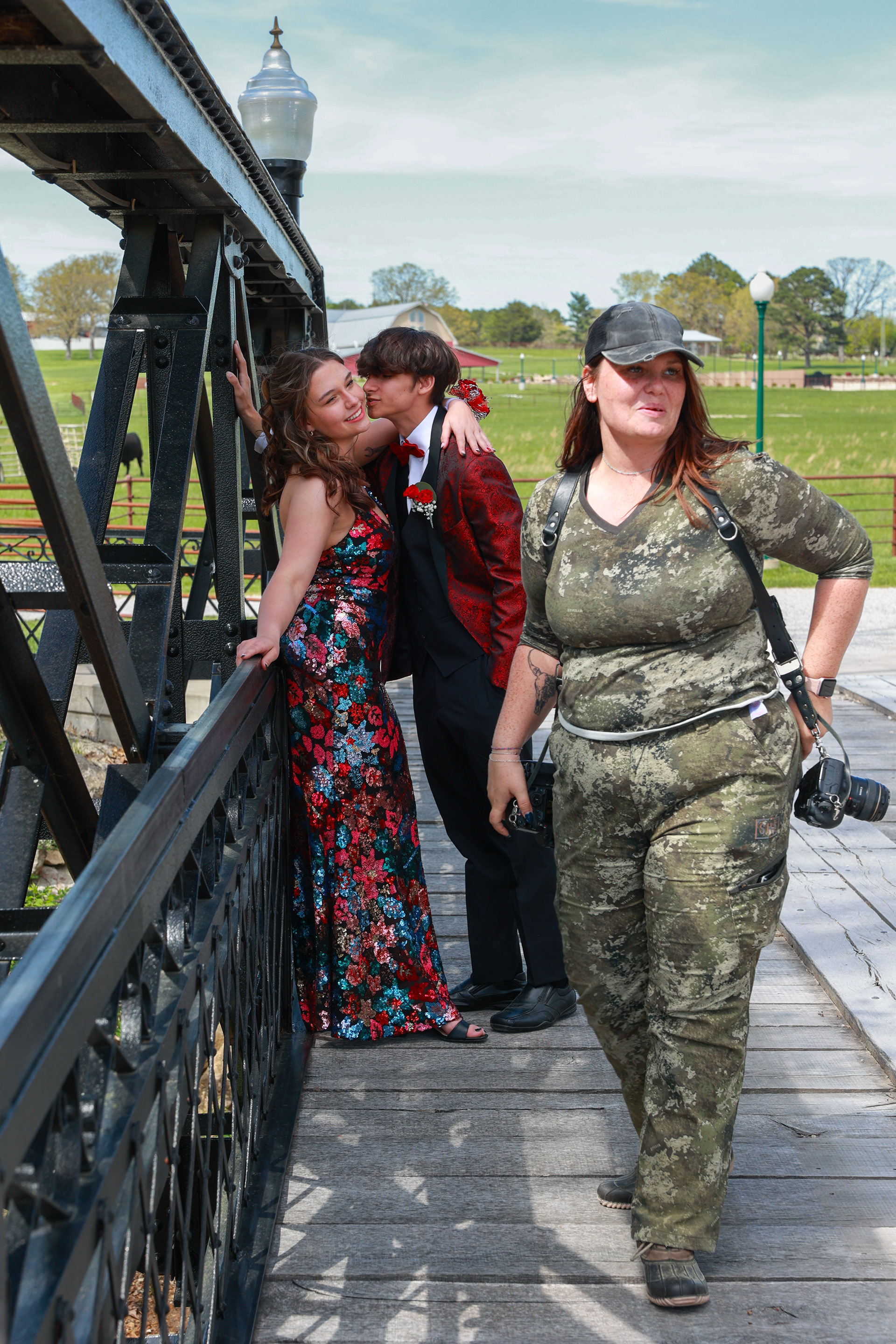 Ellie Thompson, left, and her boyfriend, fellow Owensville High School student Colton Skiles, center, laugh during a prom photoshoot with photographer Brittany Sederburg, right, on Saturday, April 20, 2024, at Red Oak Valley in Owensville, Mo. In addition to going to school and working, Thompson said she enjoys taking photos of her friends, especially those on the Owensville Dutchman baseball team, of which Skiles is a member.