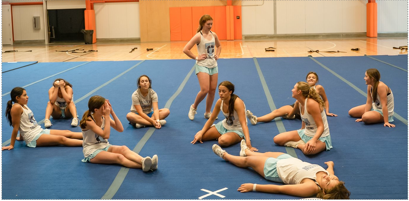 Tolton Catholic High School's cheerleading team lay down tired and frustrated after a three-hour practice on Friday, Sept. 22, 2023, in Columbia, Mo. The practice had missed stunts and incomplete routines as the regional competition approached. Despite the grind of the long day, Coach Lauren McDaniels praised her squad. "This was your first full-on. No one’s first full-on is easy. We are only building from here. Don’t be too hard on yourselves. I am really proud of you guys. I mean it! It’s all about getting our minds right first.”​