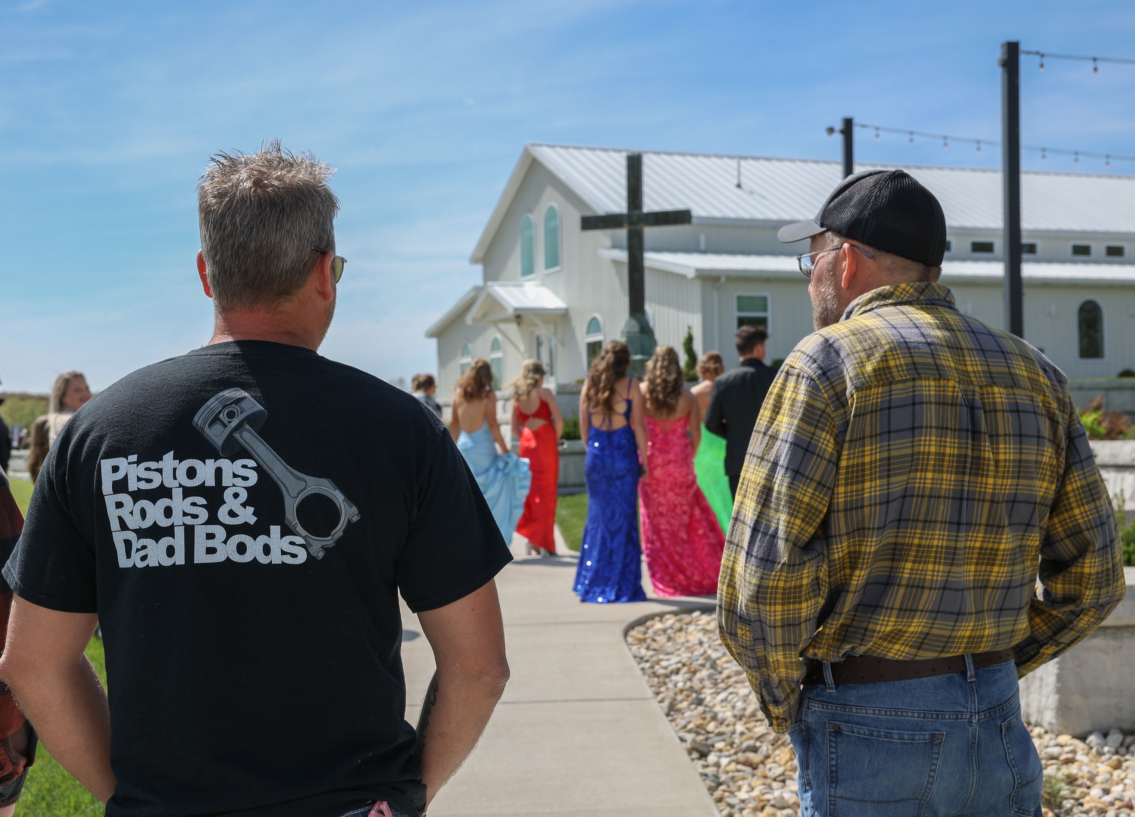 A father and a grandfather of two Owensville High School students look on as prom photos are being taken on Saturday, April 20, 2024, at Red Oak Valley, in Owensville, Mo. 