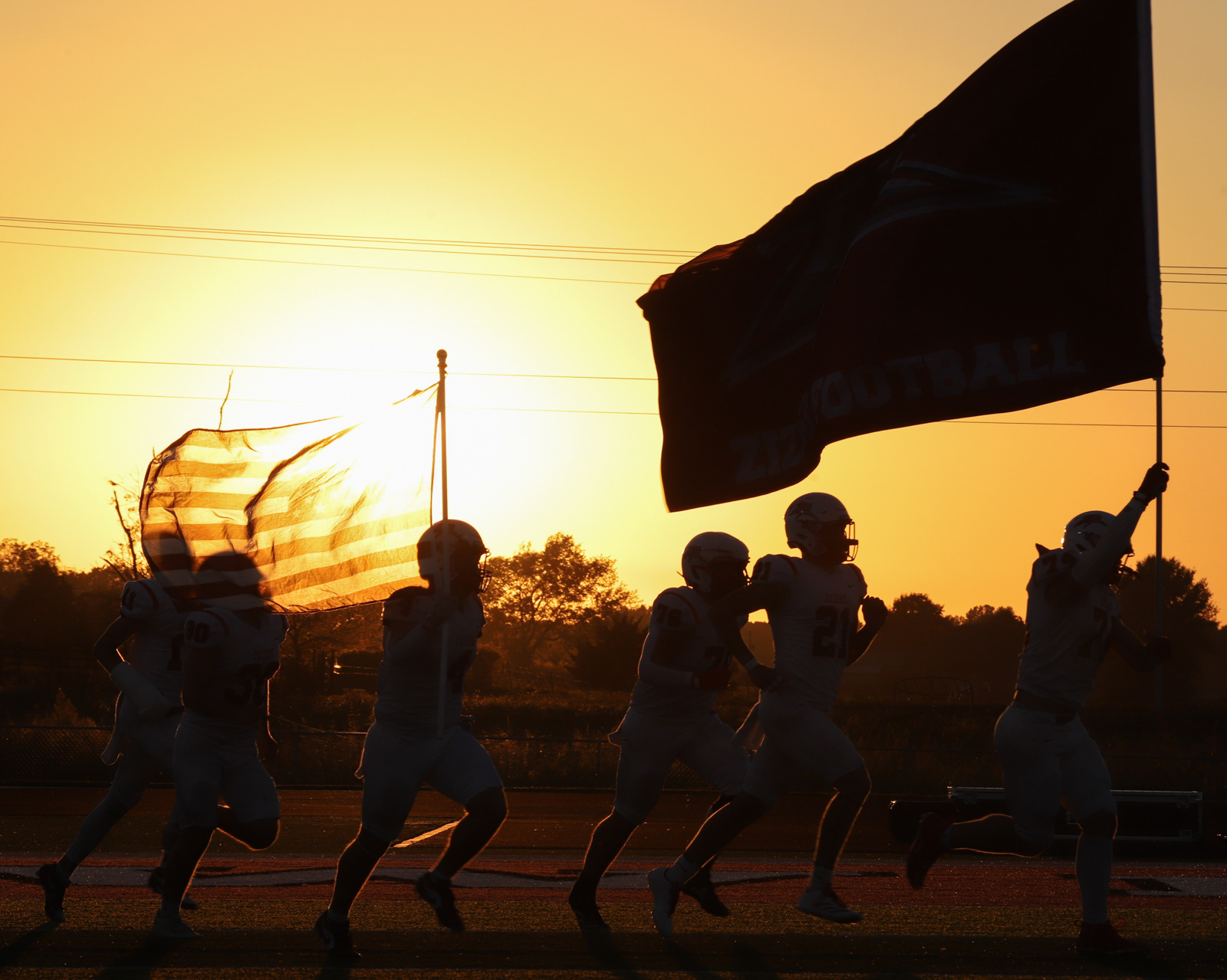 The West Plains varsity football team runs out onto the Logan-Rogersville field as the sun sets on Friday, Sept. 26, 2025, in Rogersville, MO.