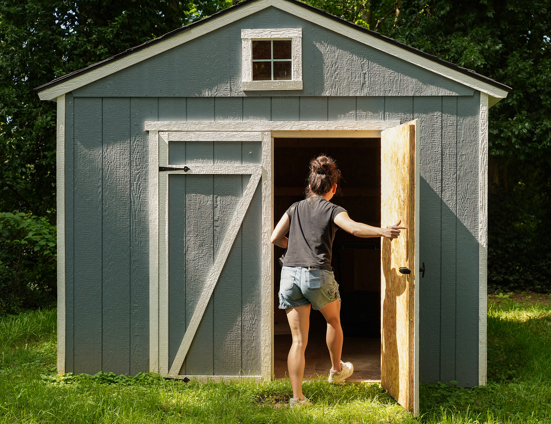 Zephanie White walks into the shed in the backyard of her new home on Wednesday, June 18, 2025, in Springfield, Mo. She moved from a leaky apartment with a parking lot that flooded, destroying her car. She bought the house, her first, with down-payment help from Restore SGF.  