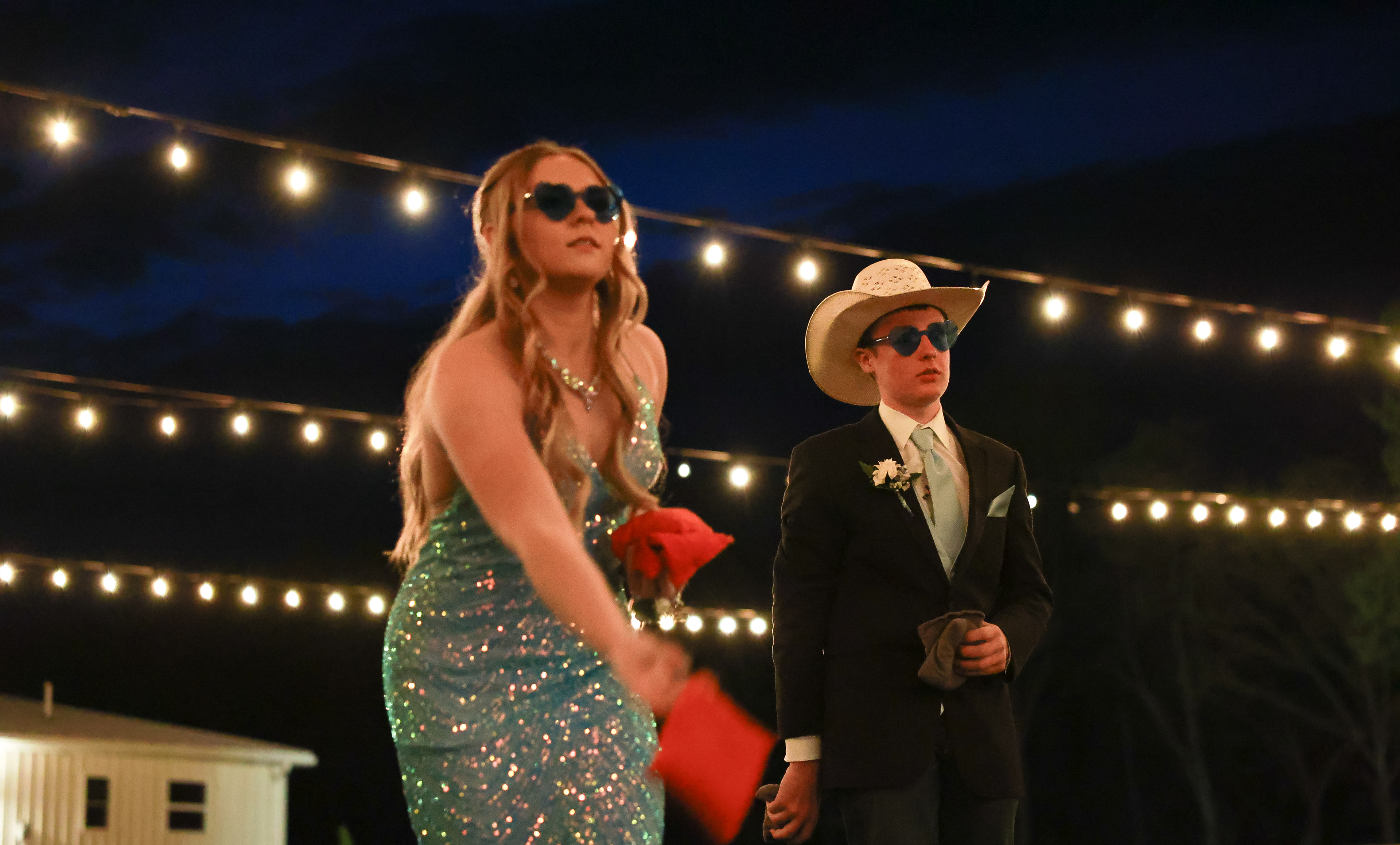 Owensville High School students play corn hole during prom on Saturday, April 20, 2024, at Red Oak Valley, in Owensville, Mo. The backyard also had giant connect four for students to play when not dancing or taking photos with people in attendance.