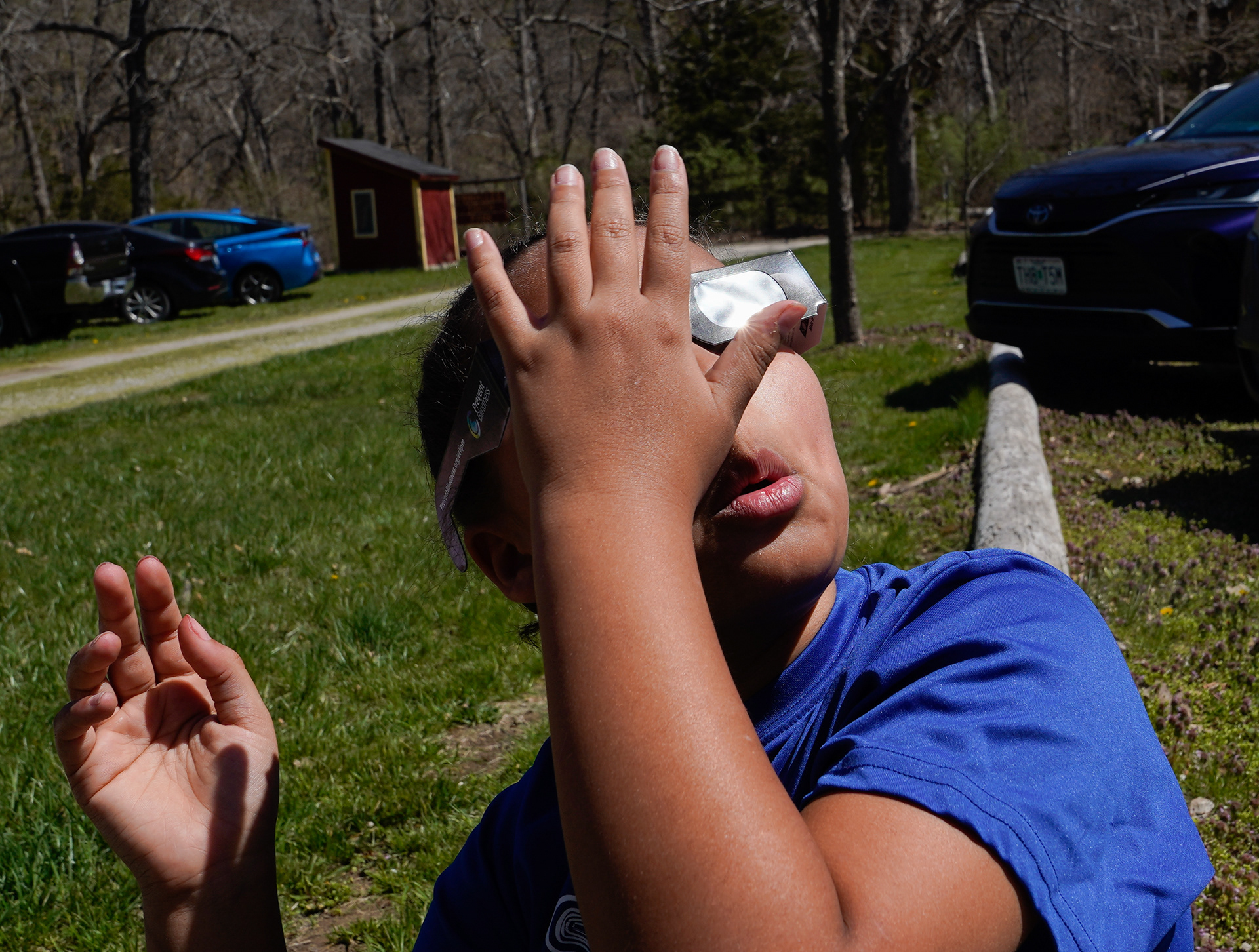 Mi’Keilee McClain, 9, puts on her glasses to watch the eclipse on Monday, April 8, 2024, in Sturgeon, Mo. Central Missouri saw the eclipse peak at 94% totality. 