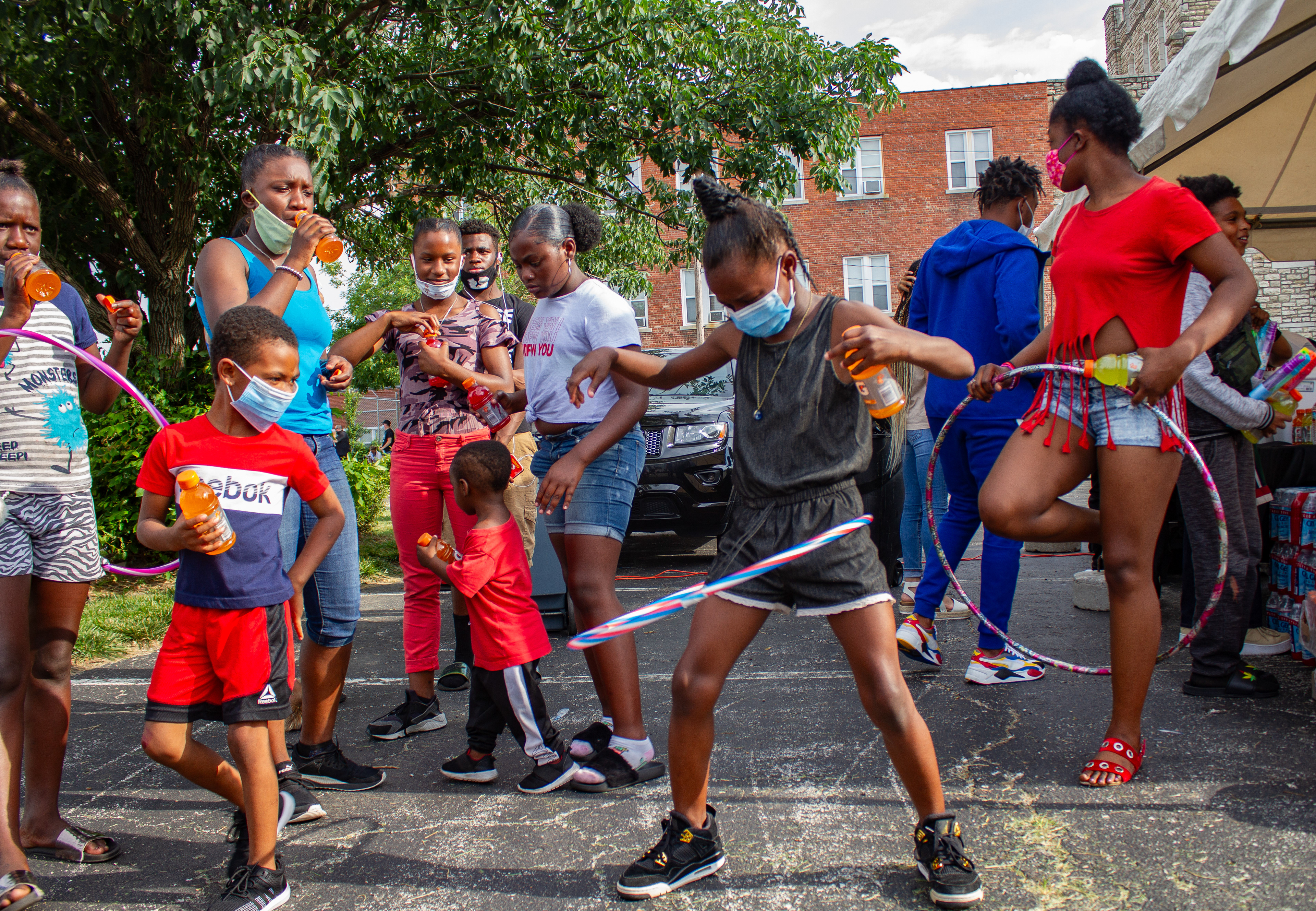 A group of young people watch a child play with a hula hoop during a Communities Creating Opportunity Juneteenth celebration on Friday, June 19, 2020, in Kansas City, Mo. The event was filled with games, events, food and pop-up businesses focusing on black culture from around the city.