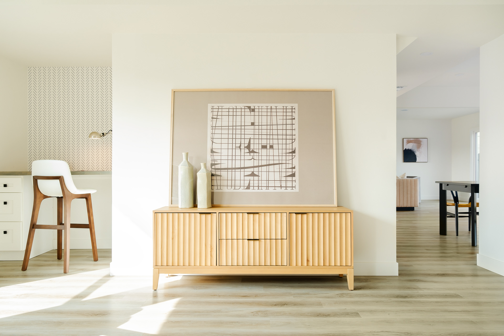 Brightly lit living room with a large framed art on the console