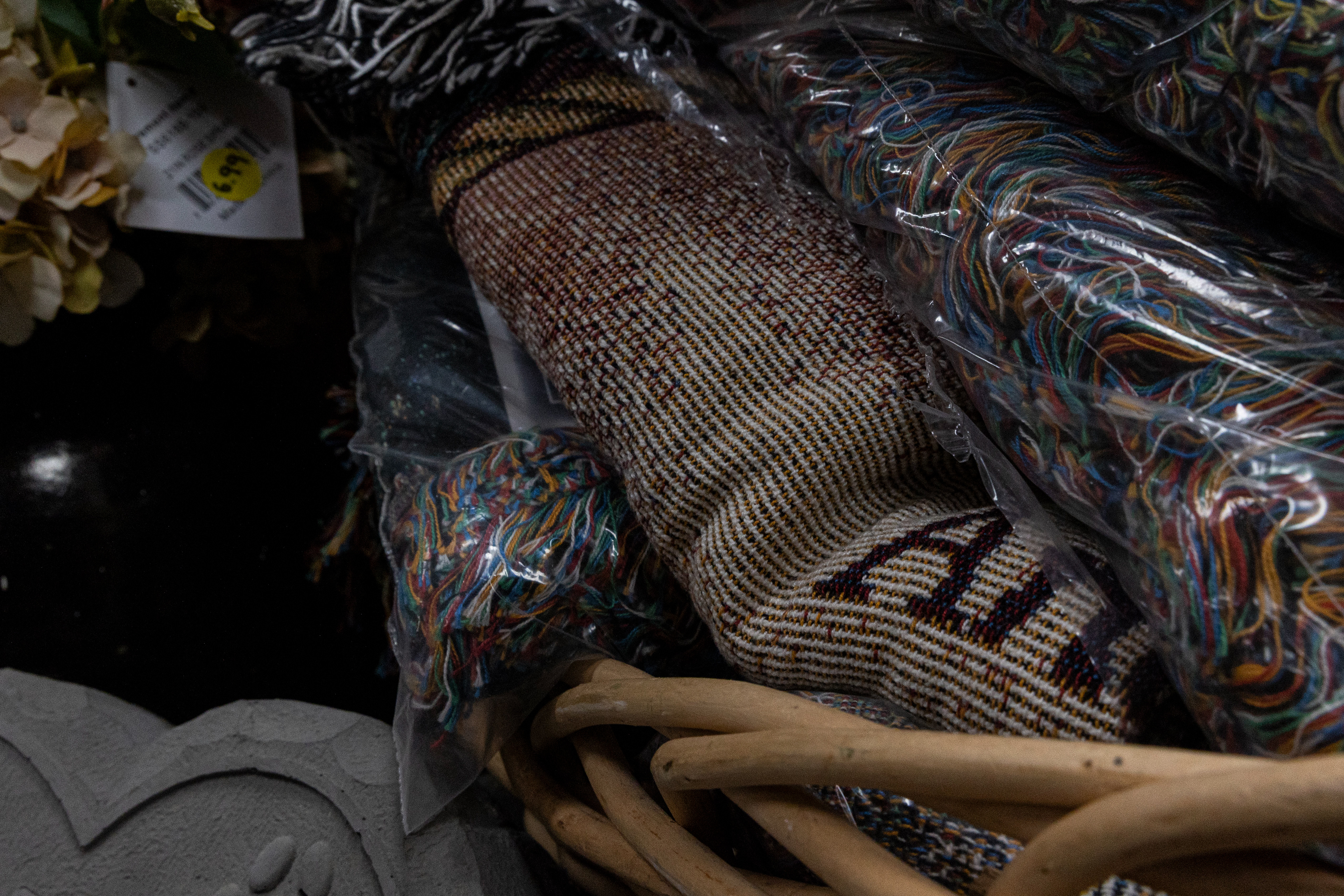 A basket of blankets sits in a corner. Polly Creech, the owner of the flower shop, says that two items blankets and windchimes, are the most popular sympathy gifts they sell. The blankets are sorted by themes such as religious, floral, or poetry. 
