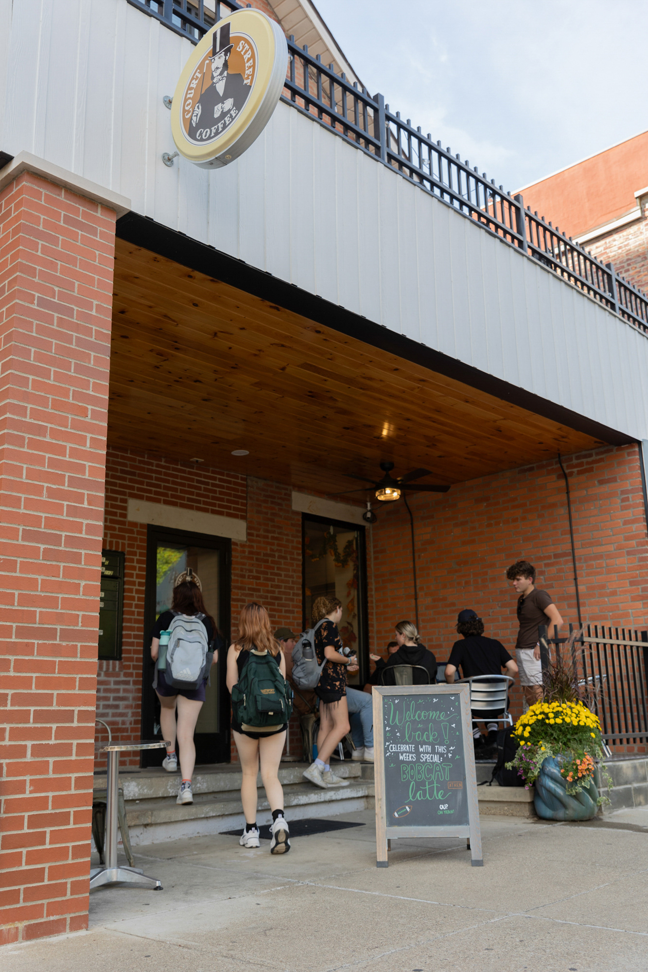 People gather to work on homework assignments at the outdoor seating for Court Street Coffee on Oct. 4, 2023, Athens, Ohio. The shop on Court Street has been open for 14 years, and there are two other locations on East State Street.