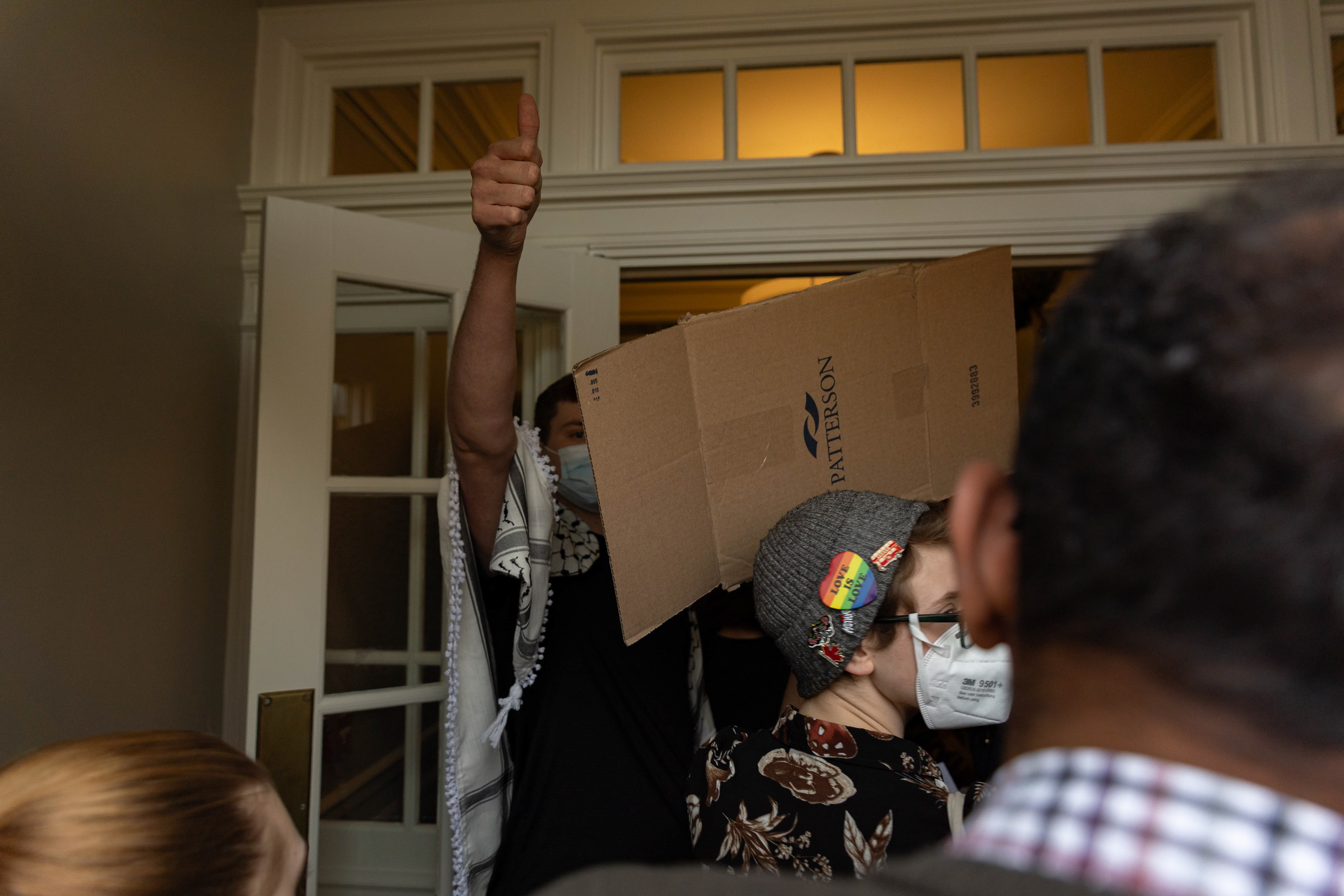 A protestor gives a thumbs up to the others to let them know that the letter of protest has been delivered to the front desk at Cutler Hall during the Athens Justice Coalition's Divest from Death campaign outside Cutler Hall, Ohio University, Feb. 26, 2025.