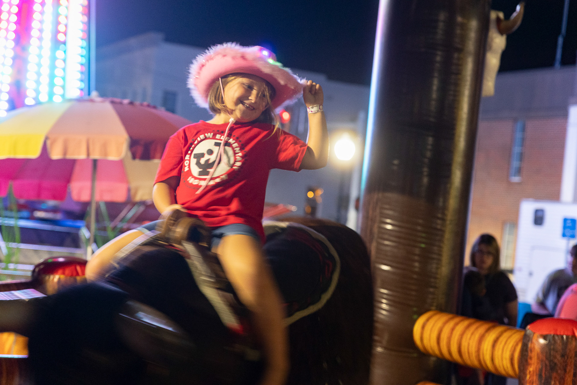 A Jackson Northview Elementary student rides the electronic bull ride at the Jackson County Apple Festival in Jackson, Ohio, Sept. 22, 2023. The electronic bull was a new addition this year to the festival and was a hit with both adults and children.