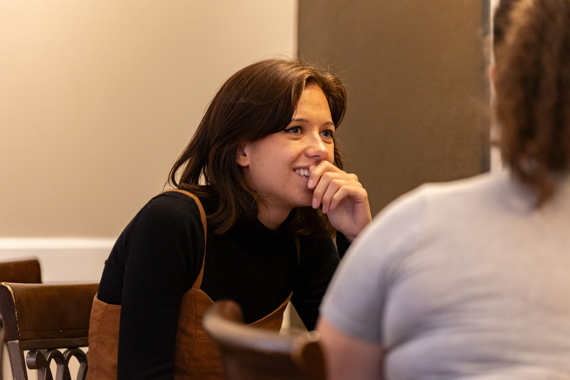 Victoria Ross smiles as she listens to a story her friend, Salina  Robards is telling her. Many people come to Court Street  Coffee just for the quiet atmosphere, sitting at the various  tables and bars to talk or do homework.