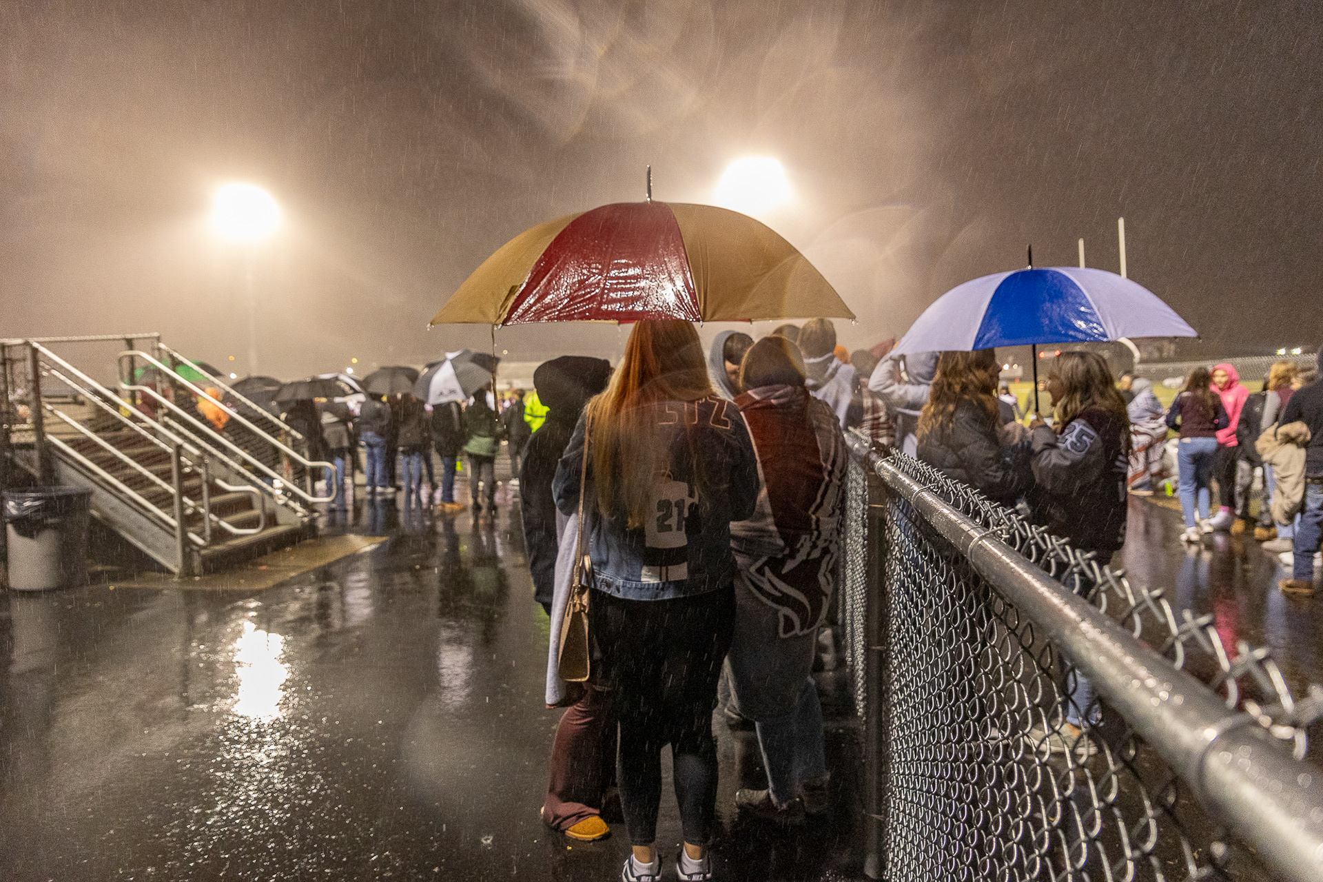 Students and parents wait in the rain for the Vinton County football team to pass by on their way to the locker rooms after their win against Wellston Oct. 20, 2023.