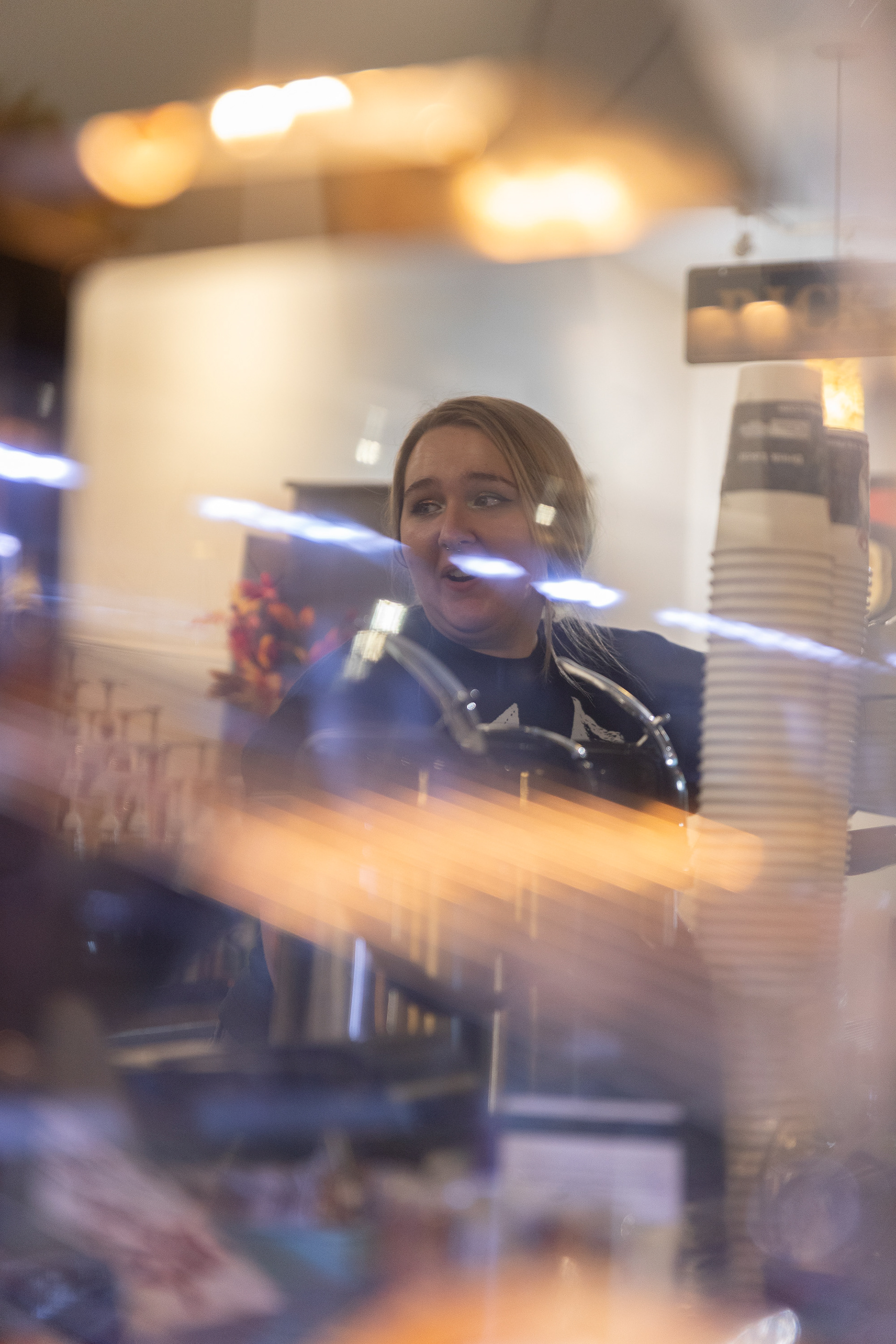 Clarissa Caldren looks over her shoulder to answer co-worker Isabele Hamm’s question about the pastry display. Pastries at  the coffee shop go quickly and the baristas are always keeping  an eye on the display in order to add more when the pastries  run low.