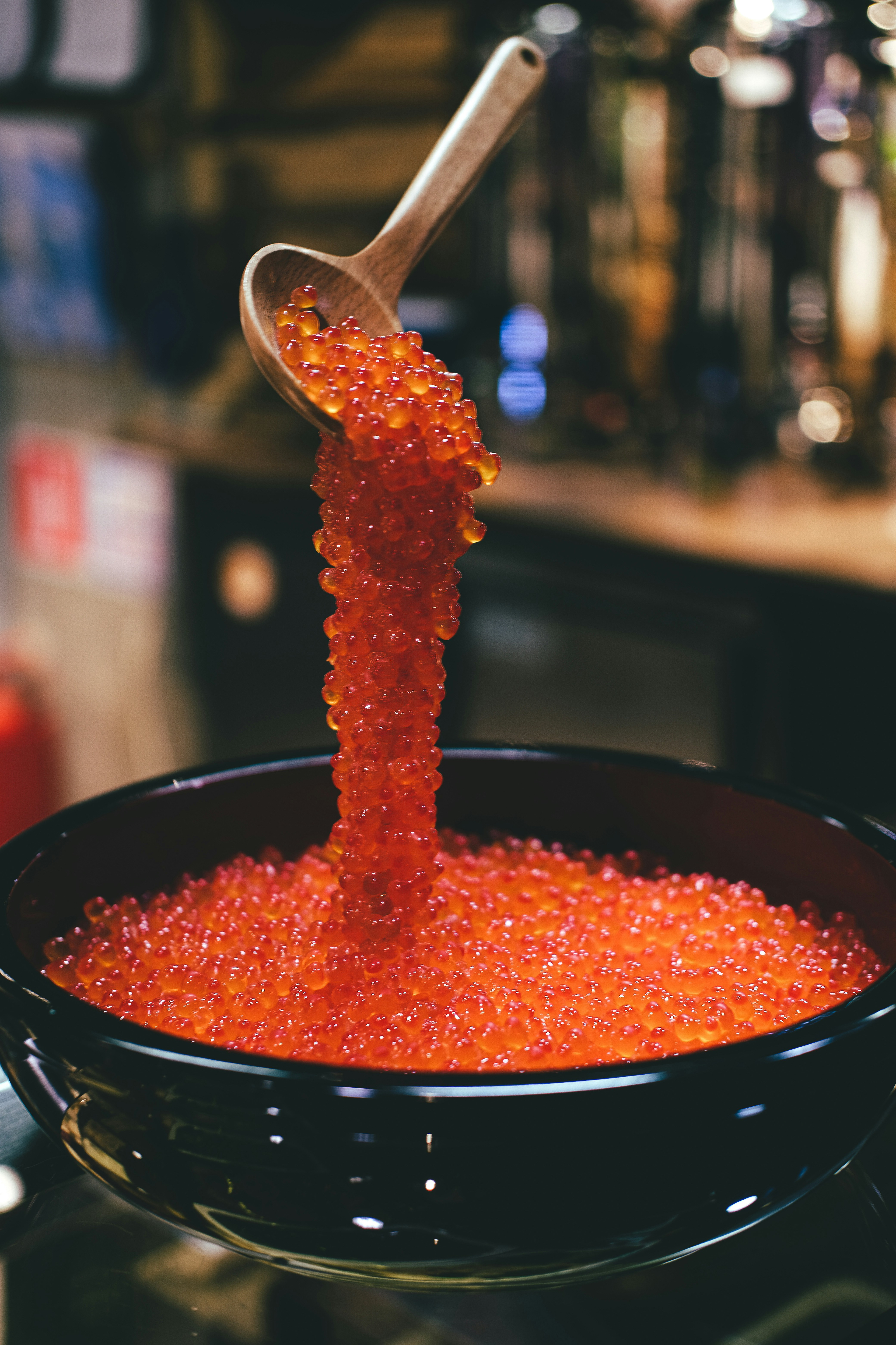 Red caviar runs down from a ladle into a pot / The Gastro Label / www.gastro-label.com