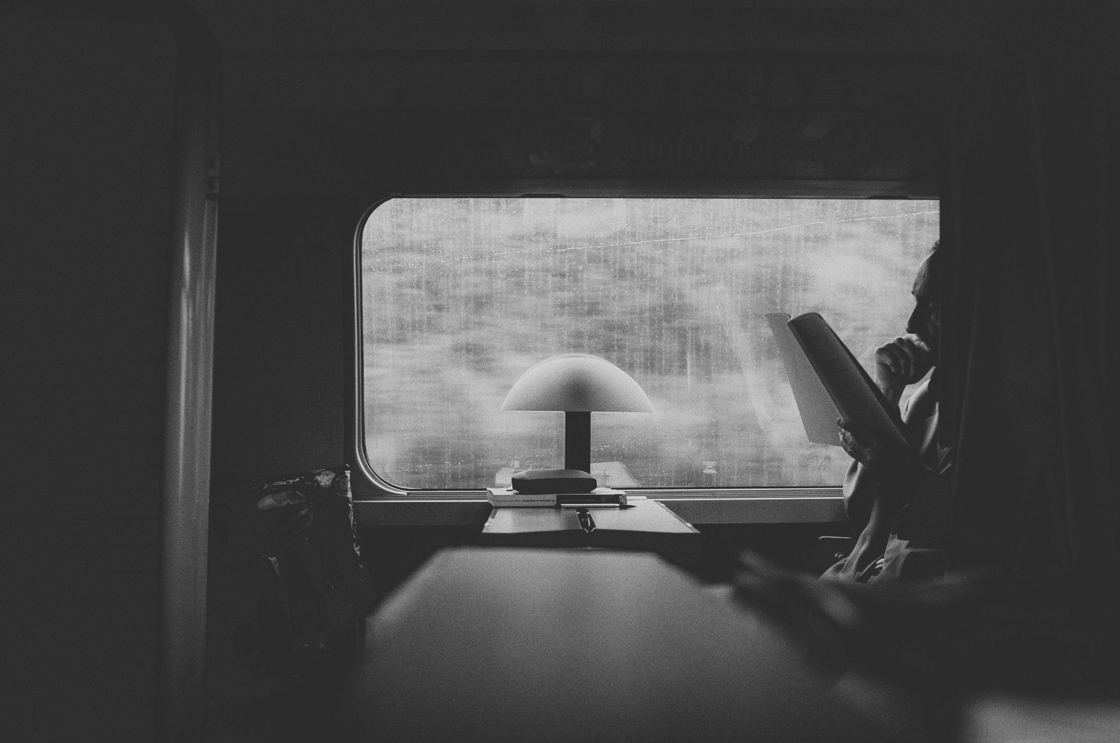 A man reads a review on a train.