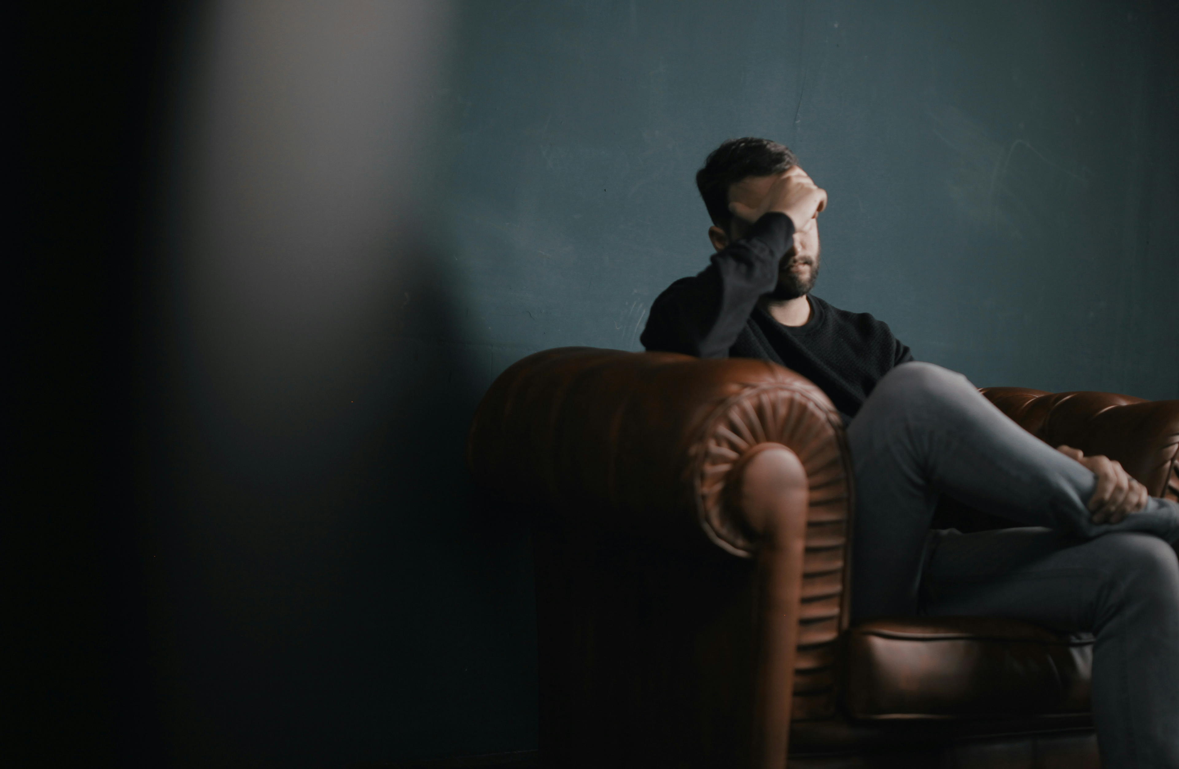 Sad man sitting on a couch with his hands over his face / The Gastro Label / www.gastro-label.com