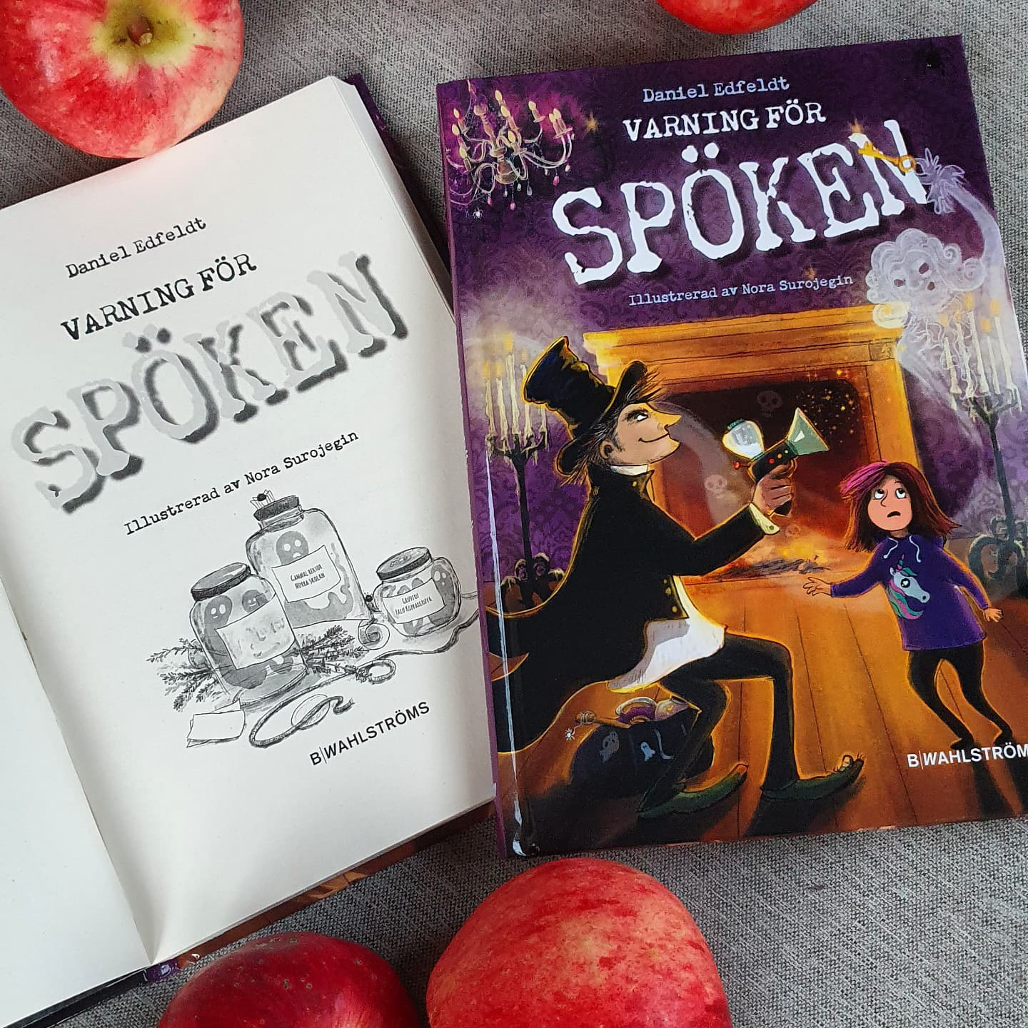 Book cover of Varning för spöken, open book and some apples.