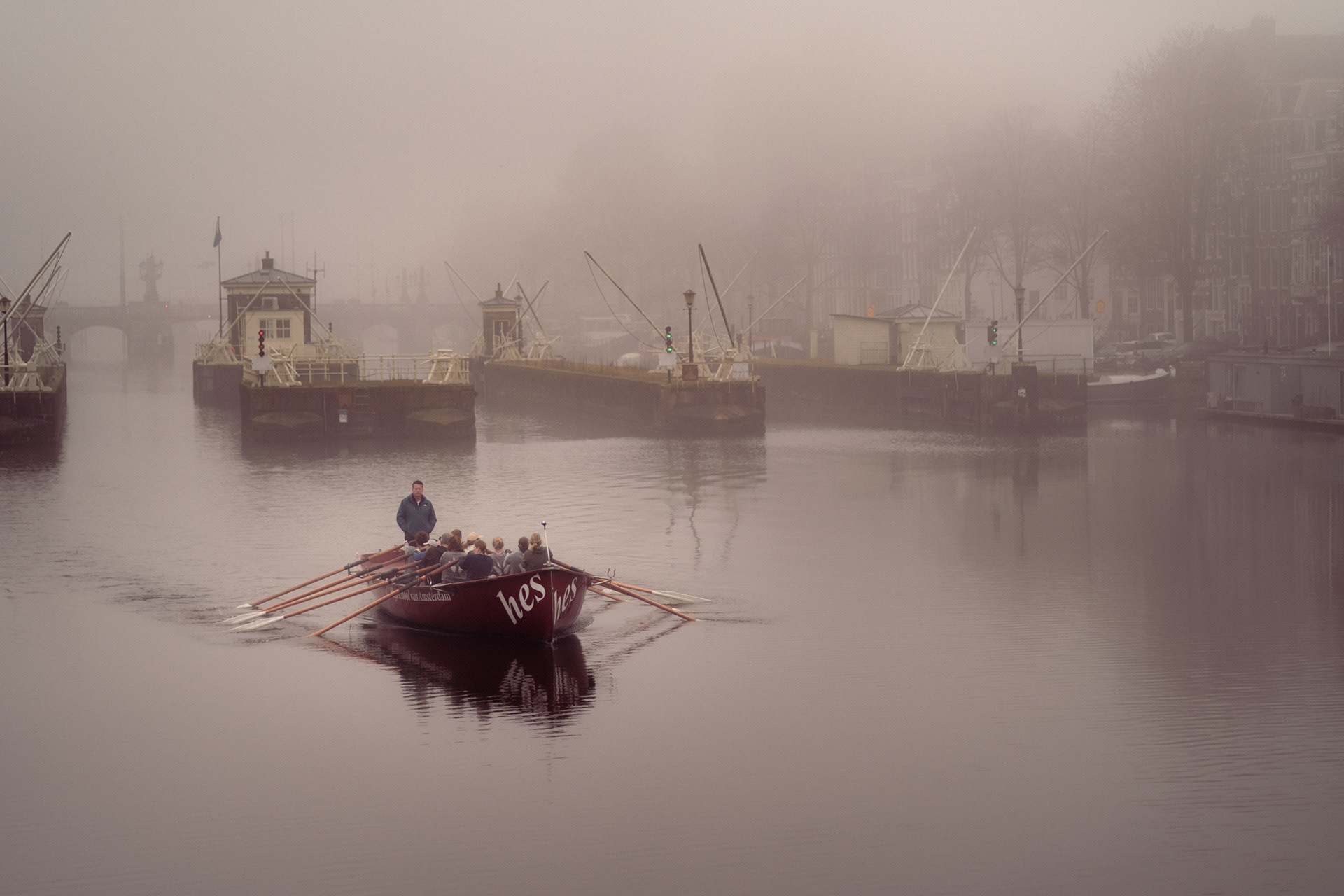 Rowing boat on an Amsterdam river in morning fog