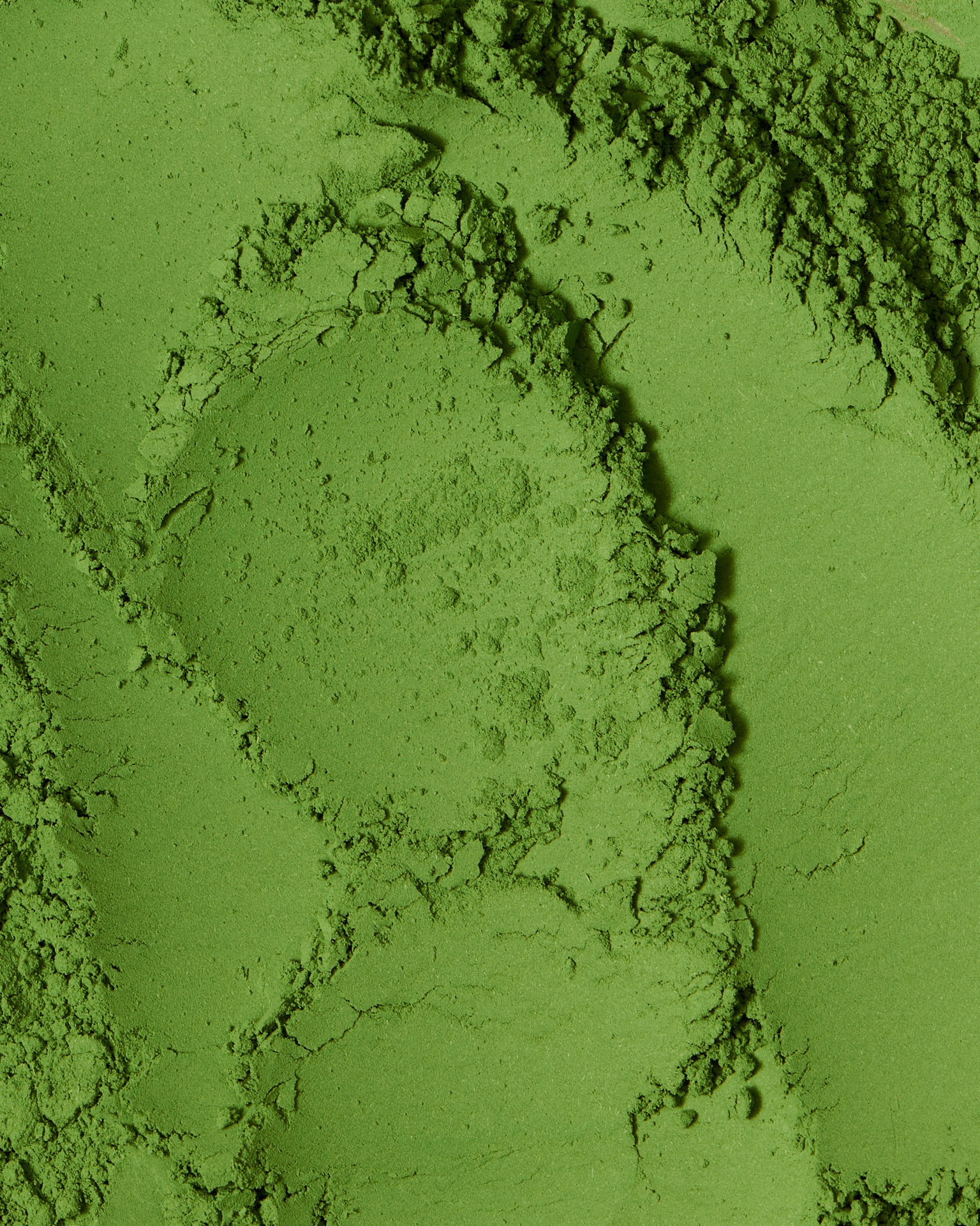 Kata Endrodi Montreal food and product photographer, close-up of vibrant green matcha powder, highlighting the fine, velvety texture and organic peaks of the tea.