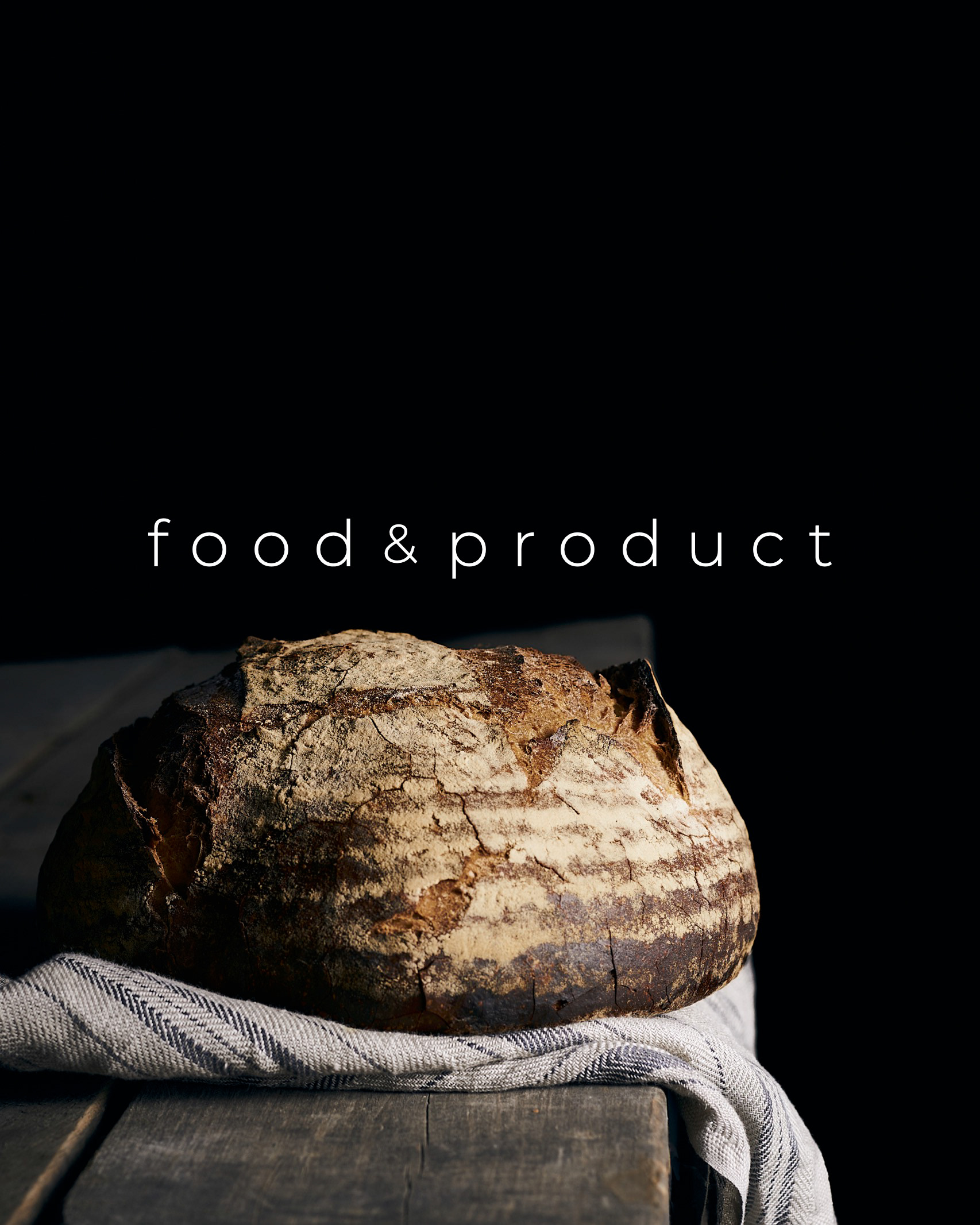Chiaroscuro food photography portrait of artisanal bread on a dark background, highlighting texture and professional lighting for brand identity.