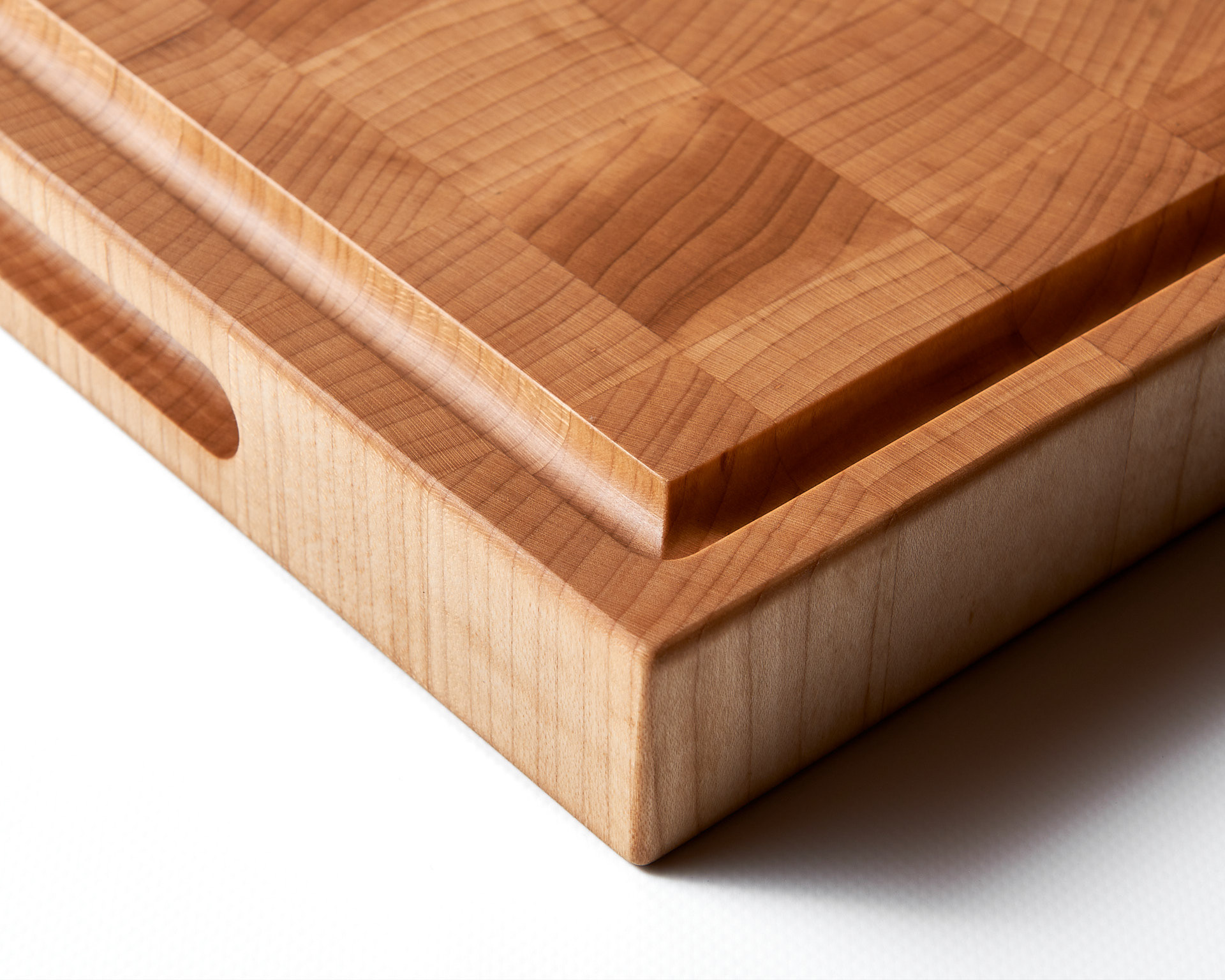 Macro photography of a wooden cutting board juice groove detail by Montreal food photographer Kata Endrodi.