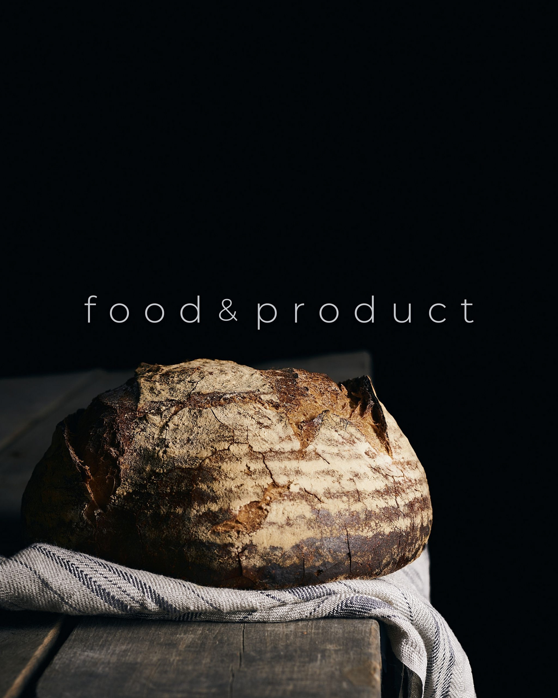 Kata Endrodi Montreal food and product photographer: A rustic, close-up shot of a sourdough bread loaf on a wooden board with linen textures, featured in the Food and Product collection.
