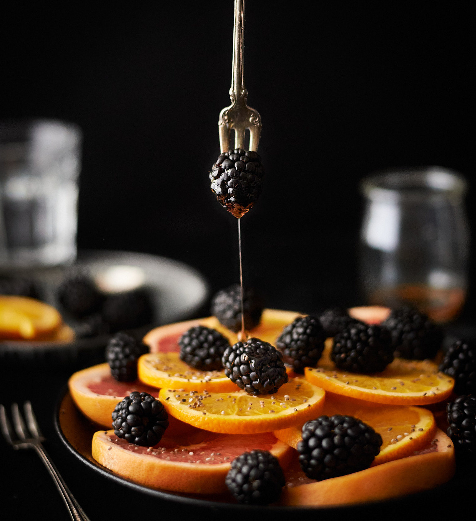 Kata Endrodi Montreal food and product photographer, close-up of maple syrup pouring over blackberries and orange slices 