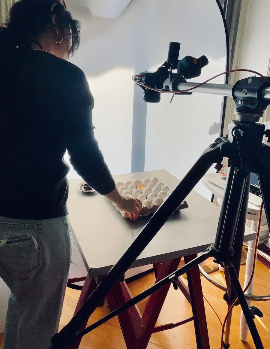 Kata Endrodi Montreal food and product photographer,  a behind a scene image with photographer, tripod, camera, arranging a carton of eggs