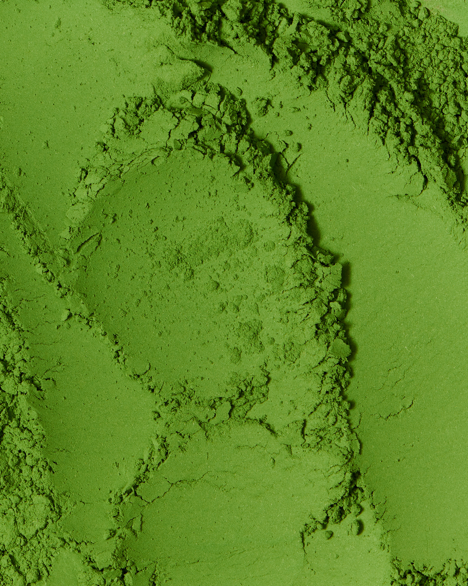 Kata Endrodi Montreal food and product photographer, close-up of vibrant green matcha powder, highlighting the fine, velvety texture and organic peaks of the tea.