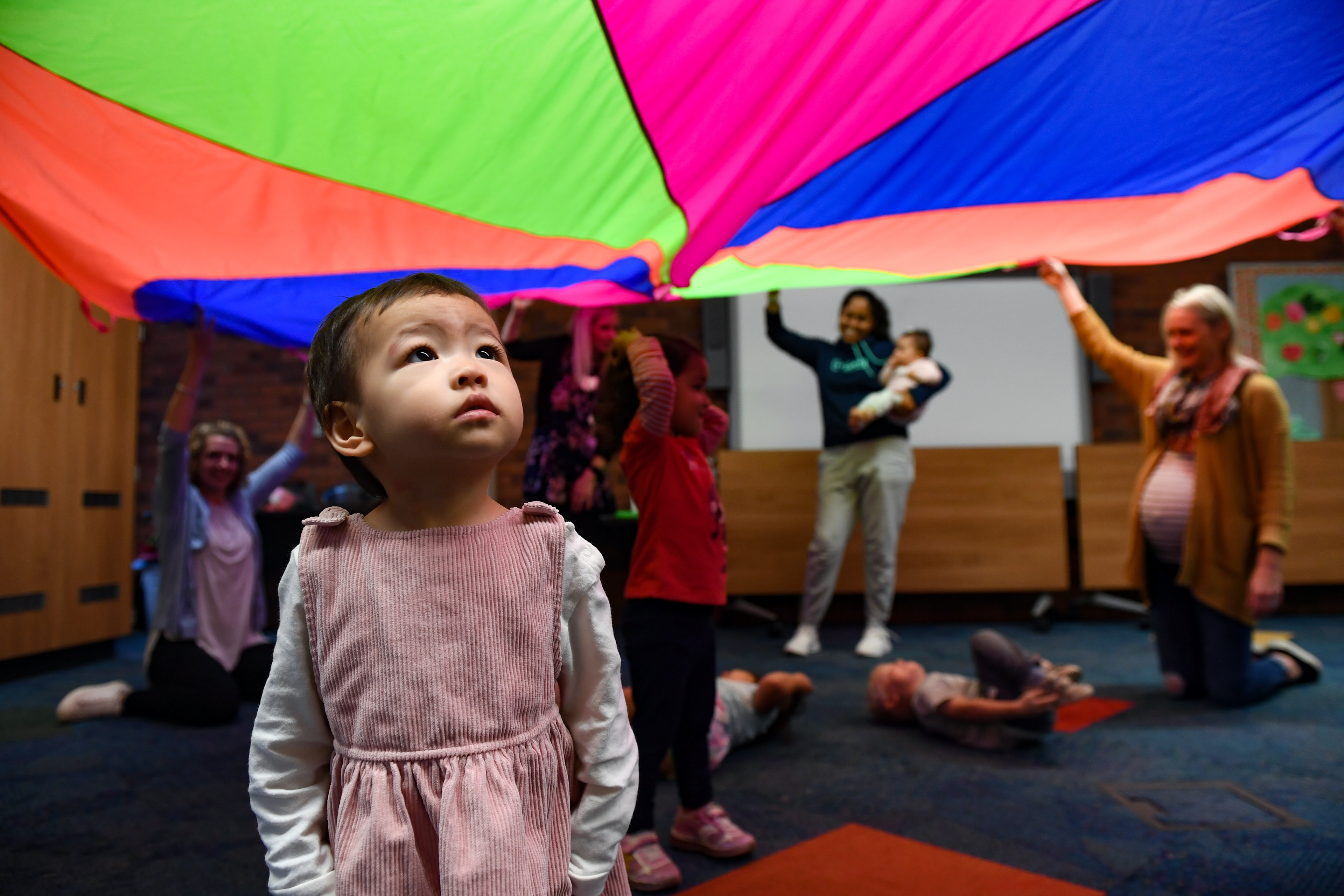 Mila Yang stares in awe at the moving colors of a parachute during a music and movement program on Friday, September 27, 2019, at the Sioux Falls downtown library.