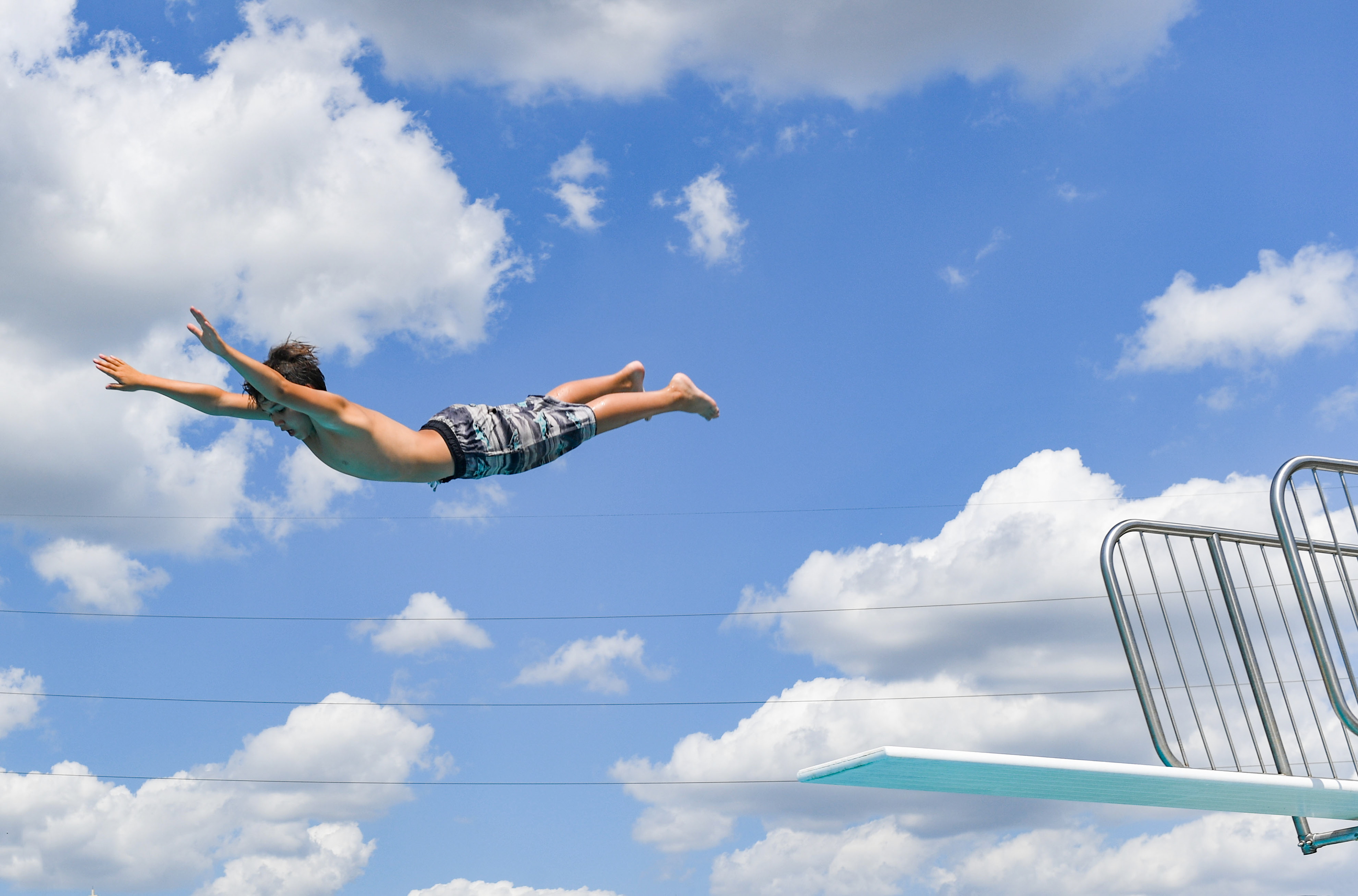 Trent Spirtk, 10, takes a flying leap off a diving board on Wednesday, June 9, 2021, at the Drake Springs Family Aquatic Center in Sioux Falls. A significant heat wave washed over the region in June, leading to crowded public pools.