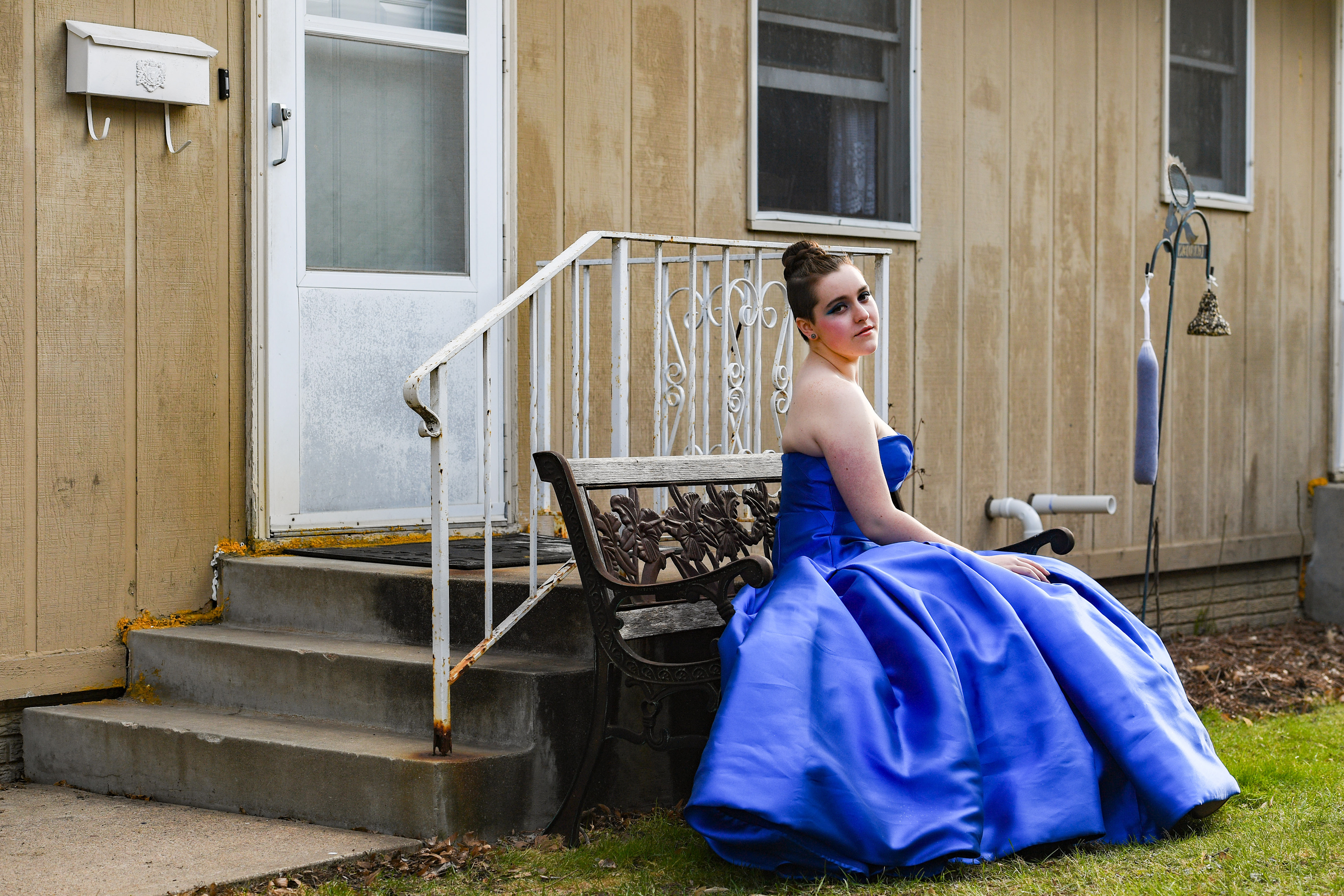 Morgan Oskar wears her prom dress in her front yard on Saturday, April 18, 2020, in Sioux Falls. Prom was canceled for the school district due to the coronavirus pandemic, though many students had already made their plans and bought their prom attire. Inspired by the queen’s gown at the renaissance fair Morgan has attended every year of her life, a blue puffy ball gown had fit the bill perfectly. Now, the Lincoln senior does feel like she’s living in a dream, but not the one she planned for. “Nothing feels real,” she said. “I’ve just been trying to keep it together, but being so isolated really sucks. PTSD, paranoia is all crashing in.”