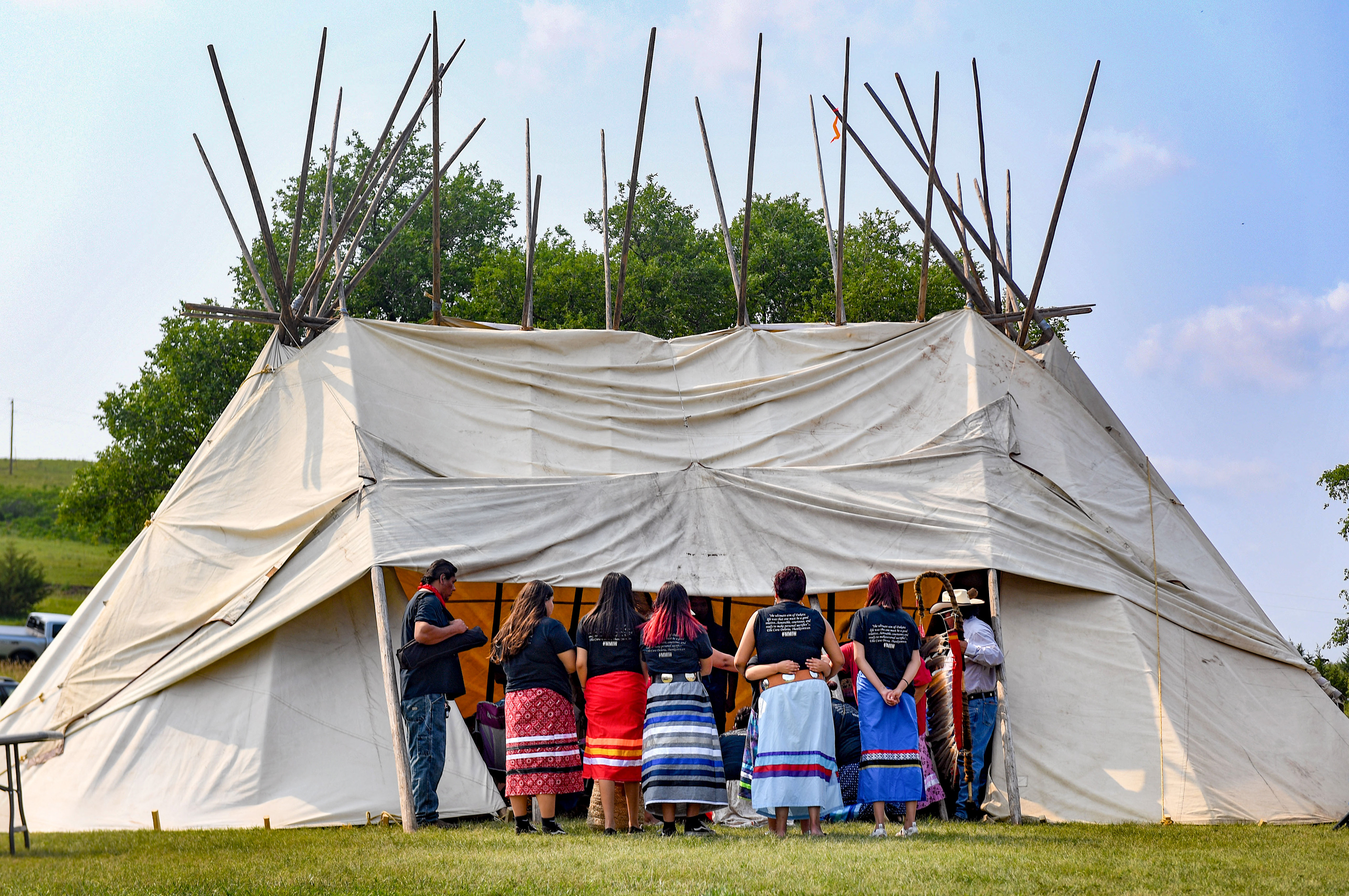 Women stand outside as a private prayer takes place with family members of the nine children on Friday, July 16, 2021 at Whetstone Landing.