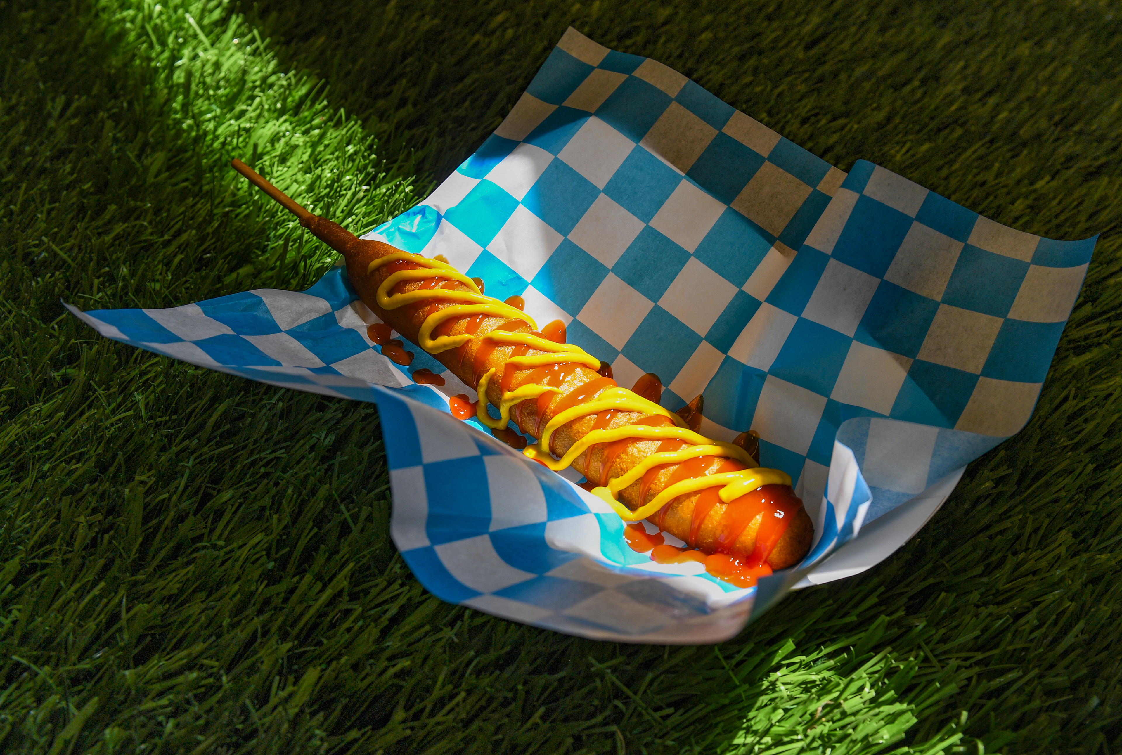 A footlong corn dog is topped with ketchup and mustard on Thursday, May 12, 2022, at the Birdcage ballpark in Sioux Falls.
