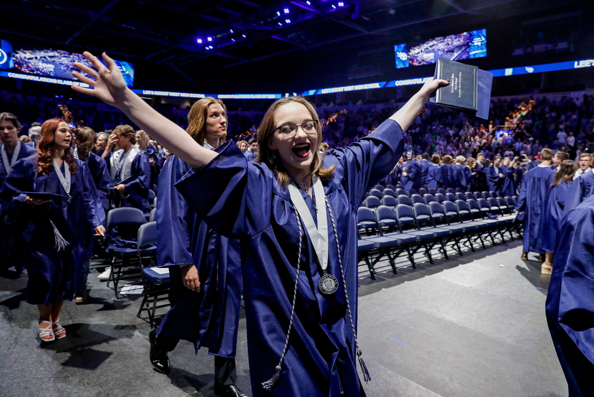 A graduate celebrates as she walks out of the auditorium following the commencement ceremony on May 22, 2024.