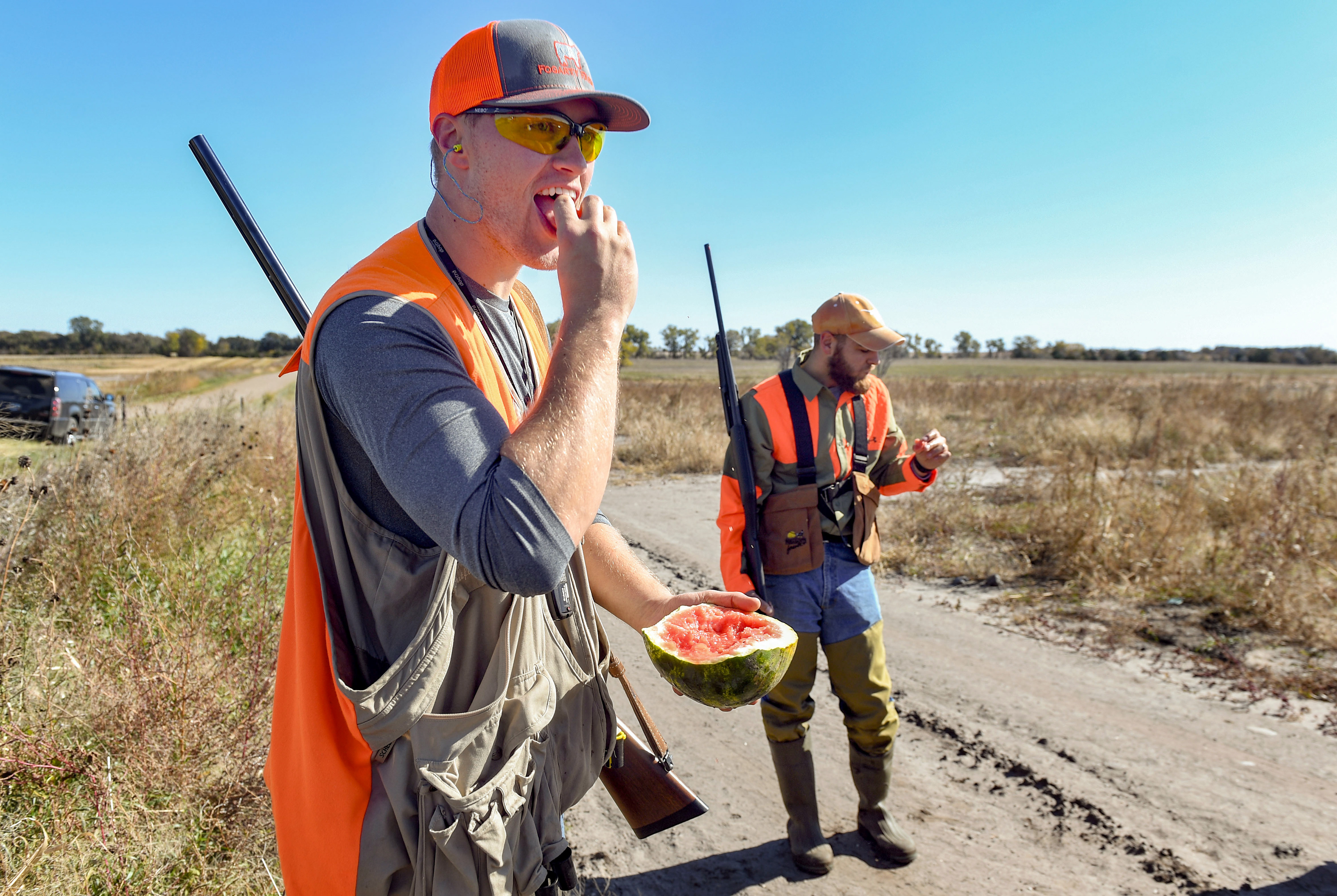 Scott Tyler takes a break from hunting to eat from a watermelon growing on the property while participating in the pheasant season opener on Saturday, October 19, 2019, in Mitchell, SD.