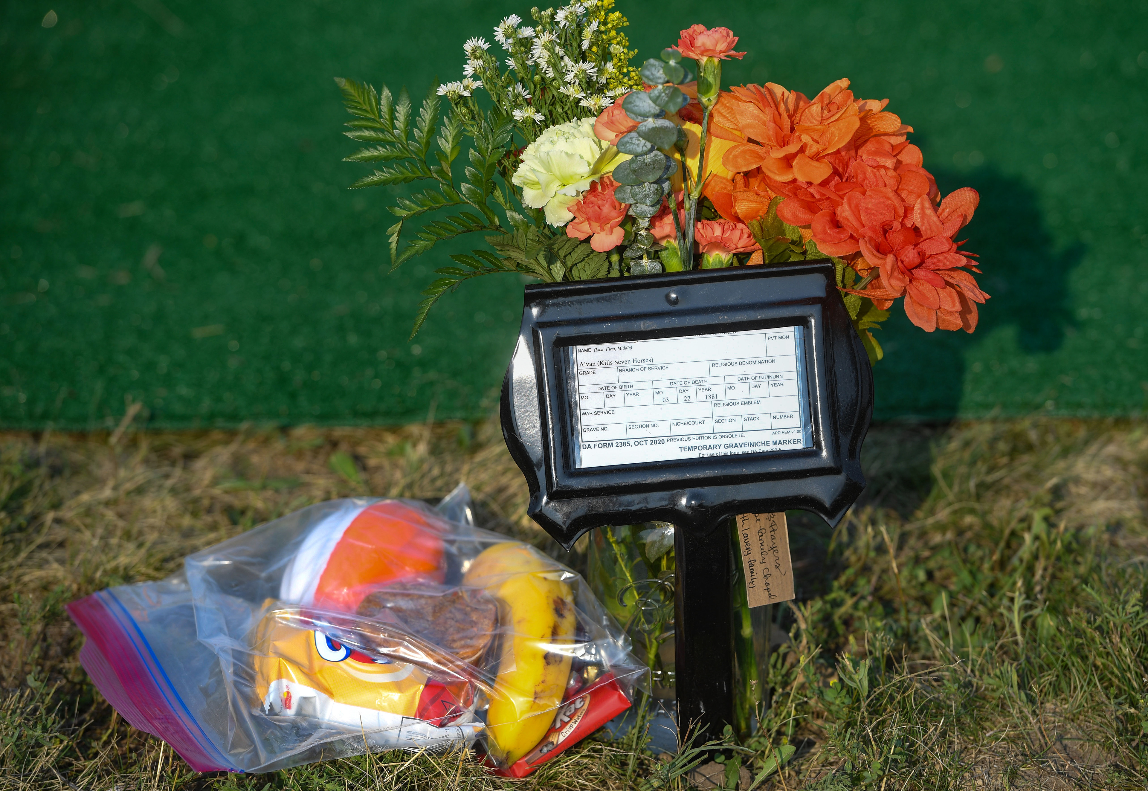 Each grave of the Rosebud Sioux children has a temporary marker until a headstone can be put in, as well as flowers and a bag of food for their journey home on Friday, July 17, 2021 at the Rosebud Sioux Tribe Veterans Cemetery.