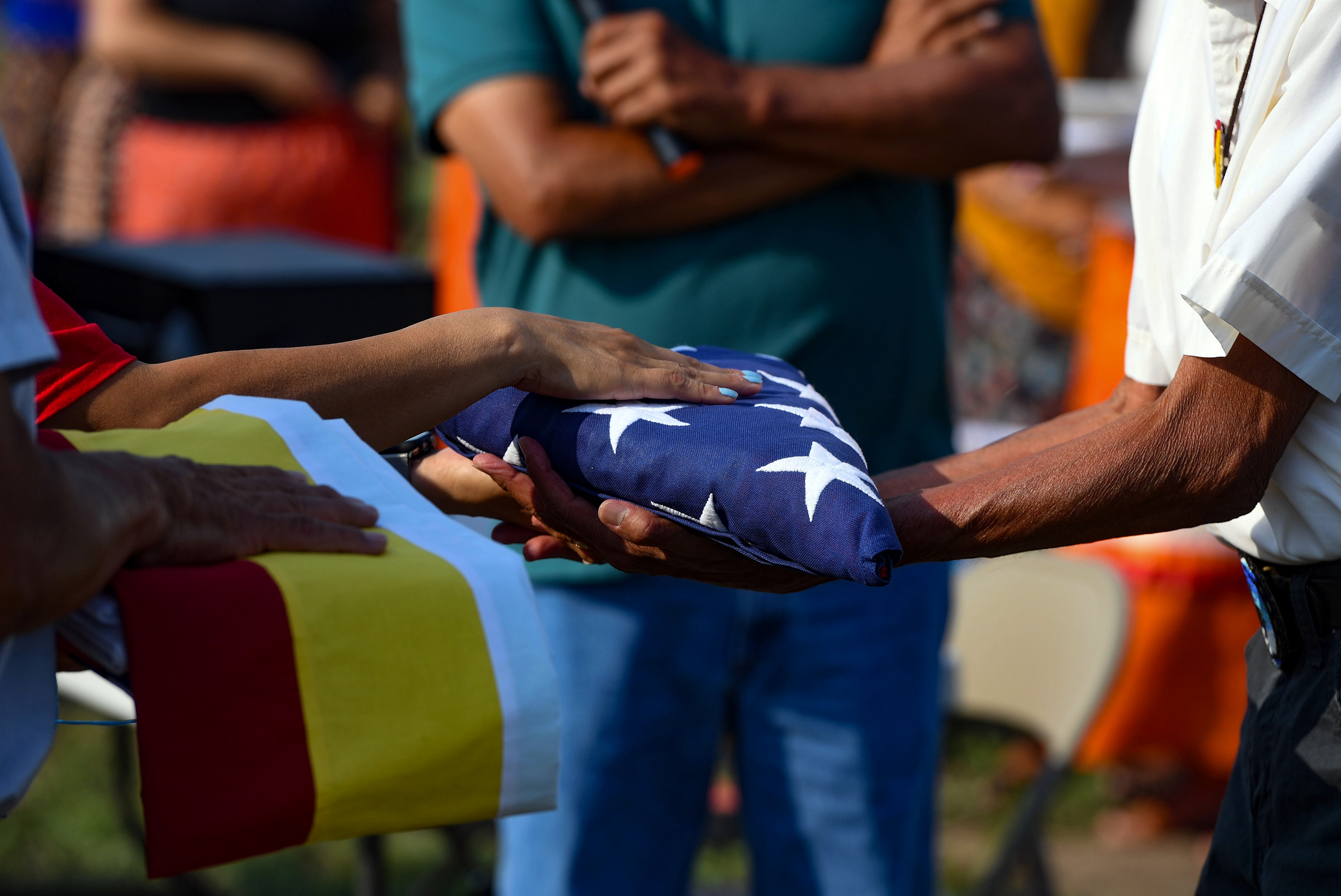 Relatives of the Rosebud Sioux children returned home 142 years after their deaths receive an American flag, a prayer flag and the Rosebud Sioux tribal flag during funeral ceremony on Friday, July 17, 2021 at the Rosebud Sioux Tribe Veterans Cemetery.