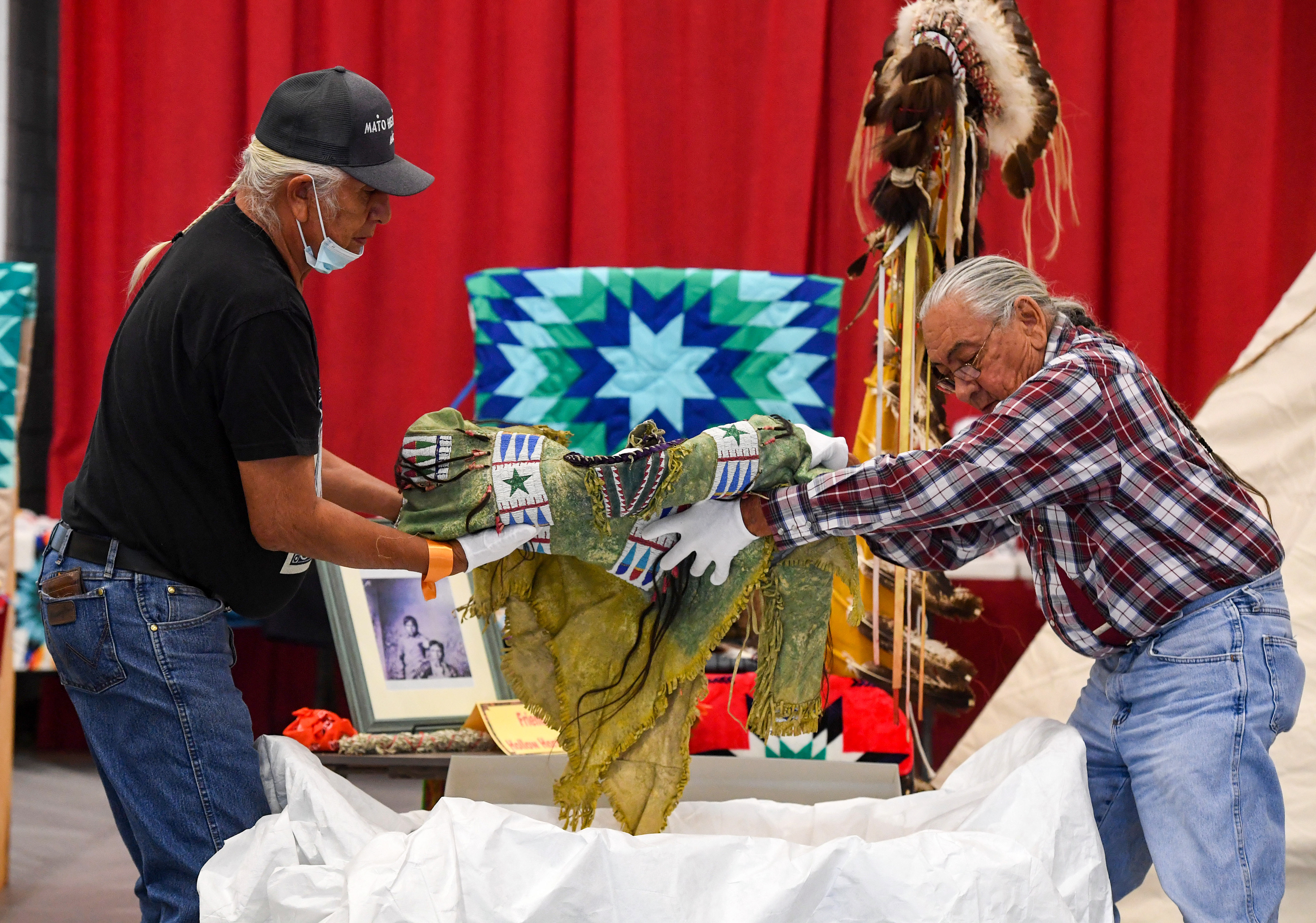 Duane Hollow Horn Bear and Sam High Crane carefully remove Hollow Horn Bear's great-grandfather's shirt from a box on Friday, July 17, 2021 at the Sinte Gleska University Student Multicultural Center. The shirt had been in a German museum for 119 years before being returned to the tribe.