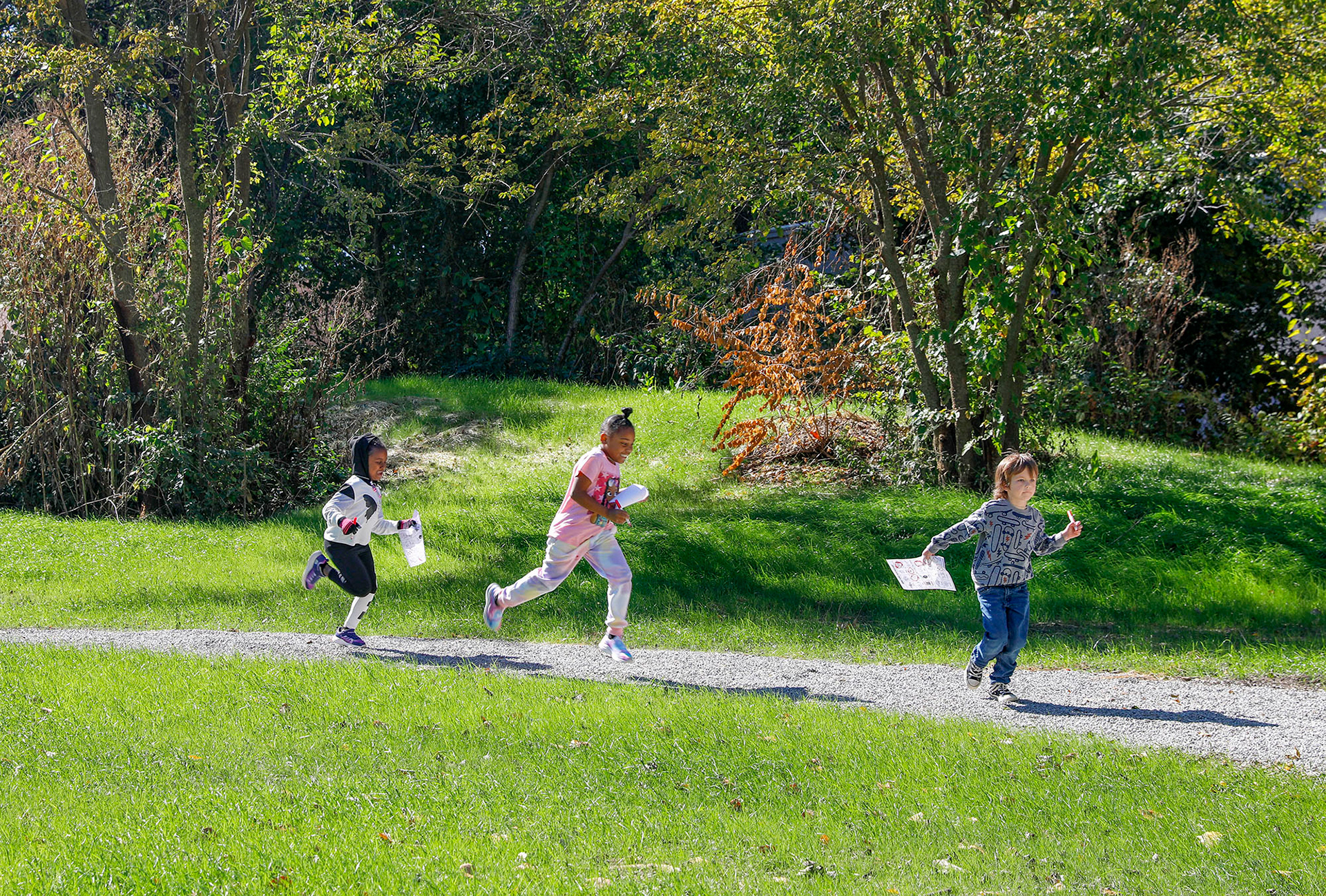 Students run along a gravel path during a field trip on October 16, 2023, at the Paradise Park campus. 