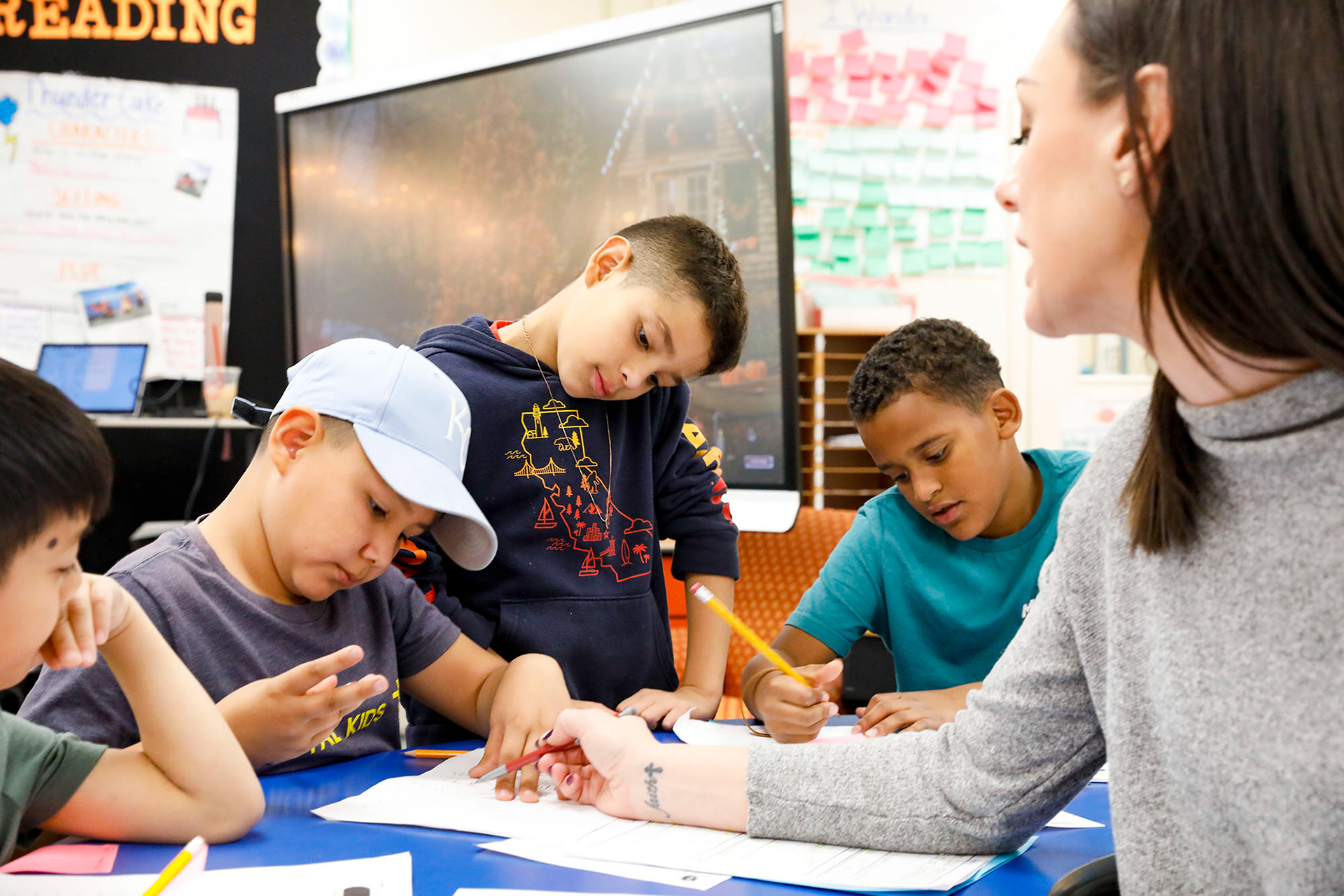 Students for whom English is a second language gather around to learn how to write multi-sentence stories on Novemer 16, 2023.