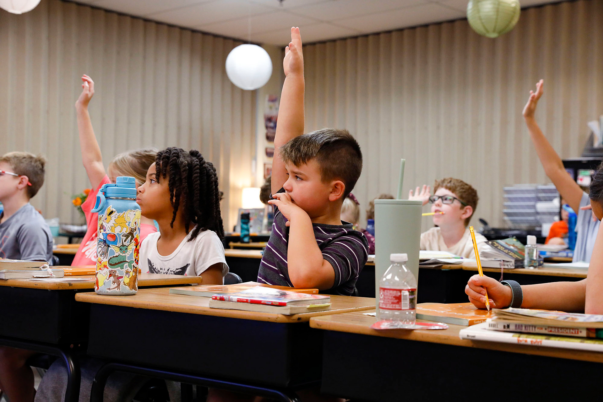 Third graders raise their hands while learning about suffixes during a spelling lesson on Tuesday, October 3, 2023, at Sunset Valley Elementary.