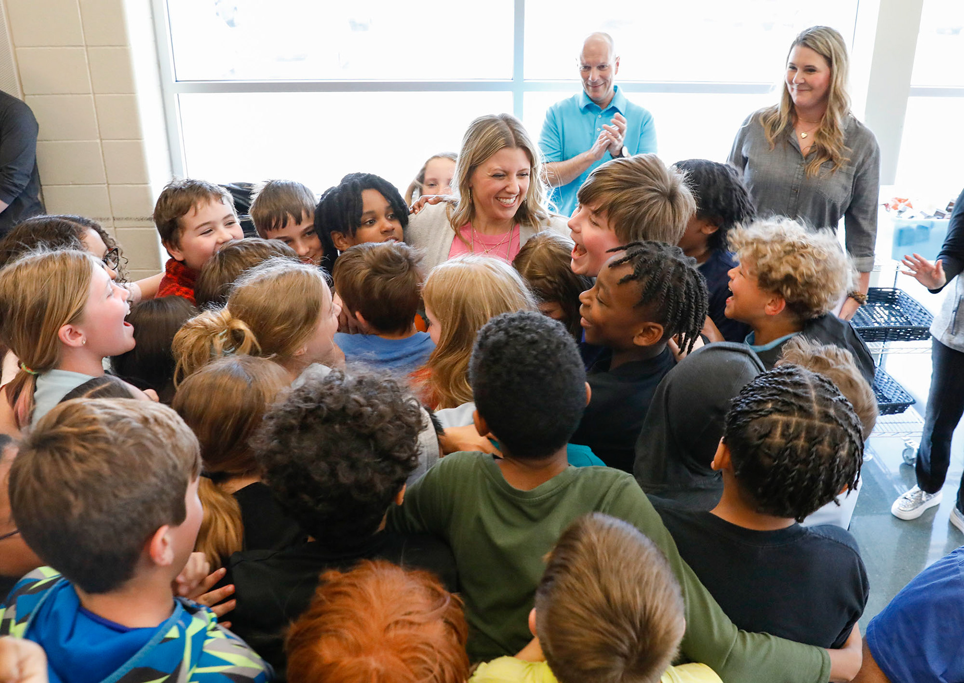 Fourth grade teacher Andrea Lanning is swarmed by students running to hug her during a surprise announcement that she won a district Excellence in Teaching award on March 29, 2024, at Summit Pointe Elementary School.