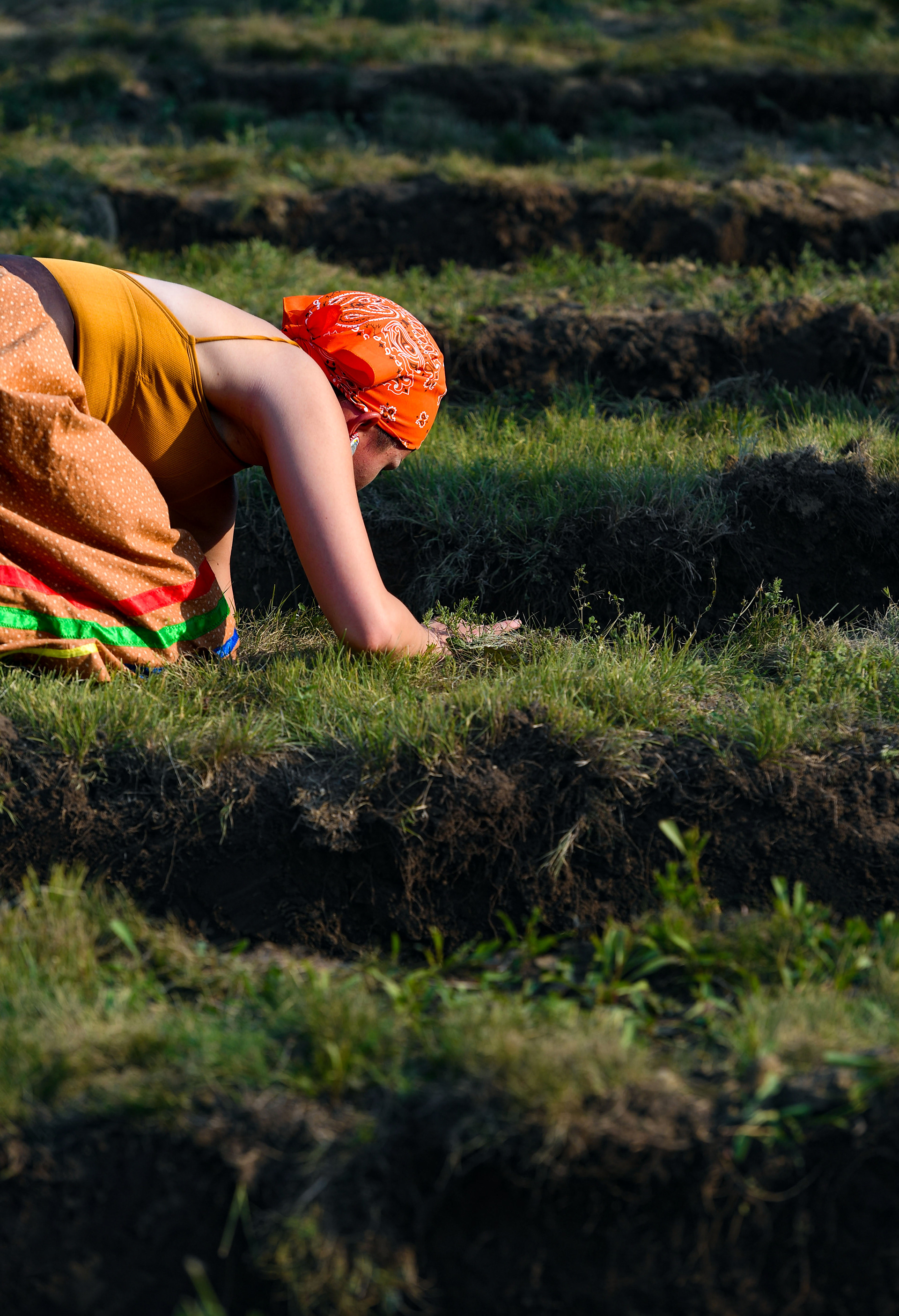 Tania Bartlett reaches down to place something in the grave of her relative, Maud Little Girl Swift Bear, at a funeral 142 years after her death on Friday, July 17, 2021 at the Rosebud Sioux Tribe Veterans Cemetery.