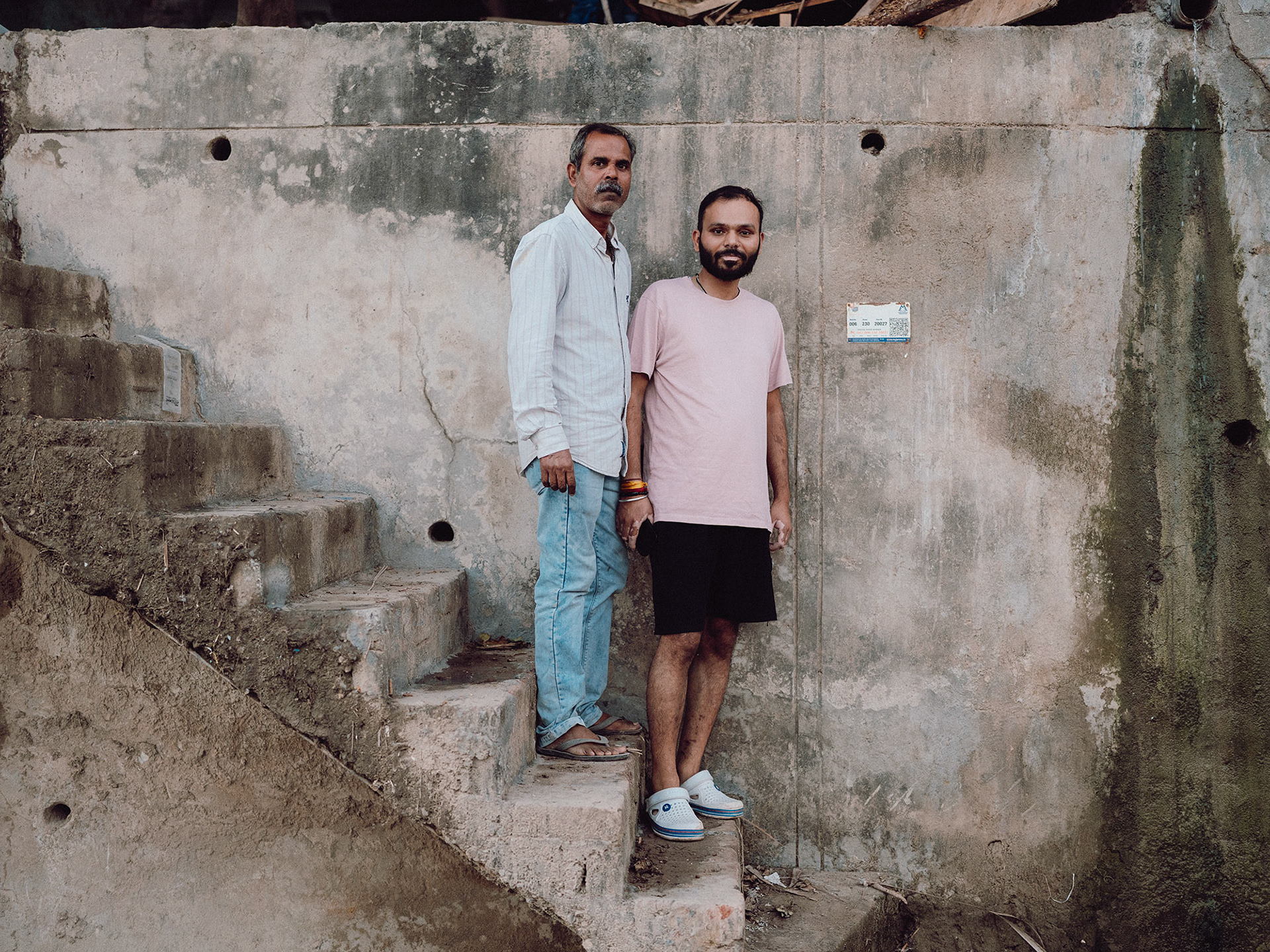 Honey and his dad in front of the flood barrier that where supposed to keep their house along the river Tawi in Jammu