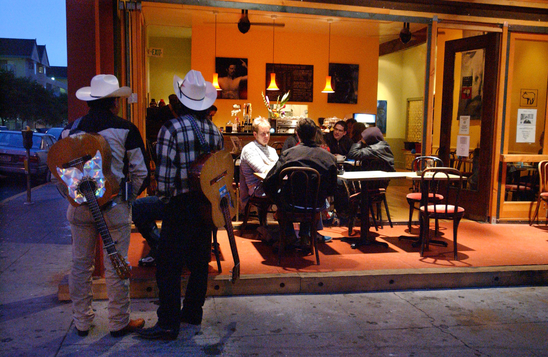 Mariachi players listen to Teja Gerken play his guitar at Papa Toby's Revolution Cafe