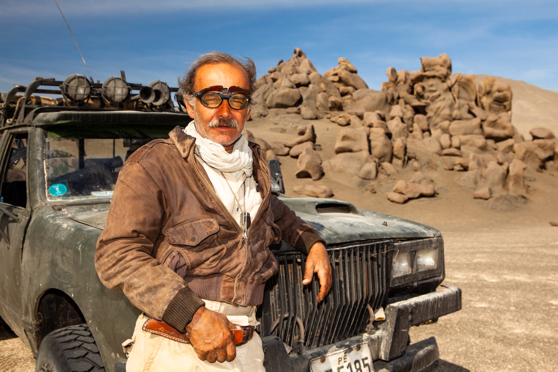 Roberto Penny Cabrera with his truck, Hermalinda, which he trusts to carry him across the roadless expanses of Peru's Ocucaje Desert. At one time the bottom of the ocean, this land is now mostly dry sand and stone, strewn with the fossils of prehistoric whales and sharks.