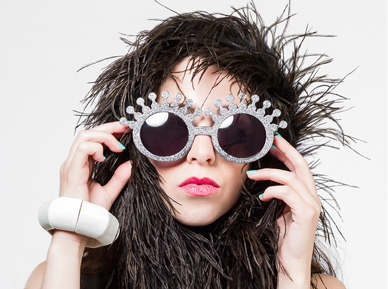 Portrait of cool looking woman with sunglasses and feather boa