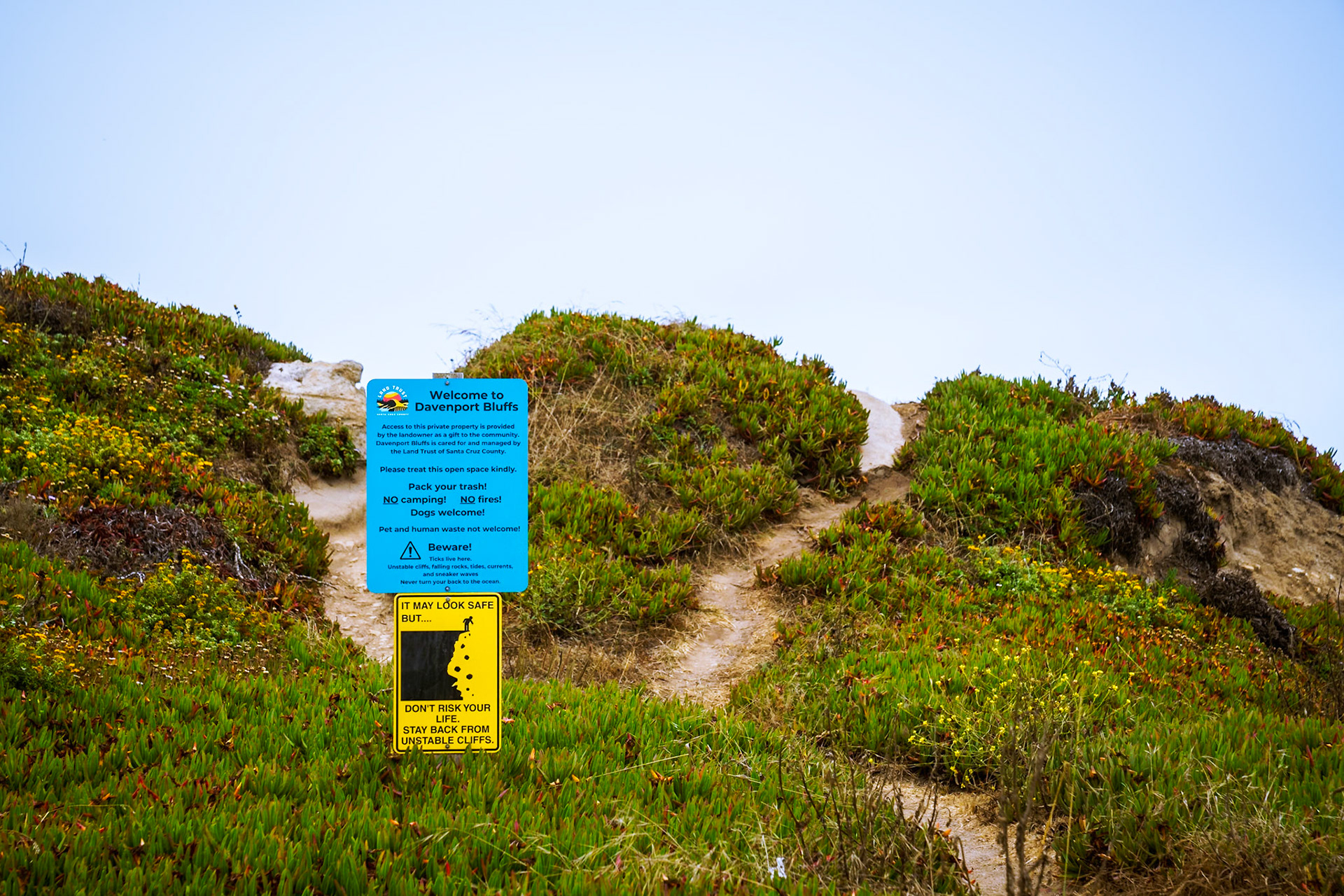 Several warning signs litter the edges of the cliffs at beach access points.