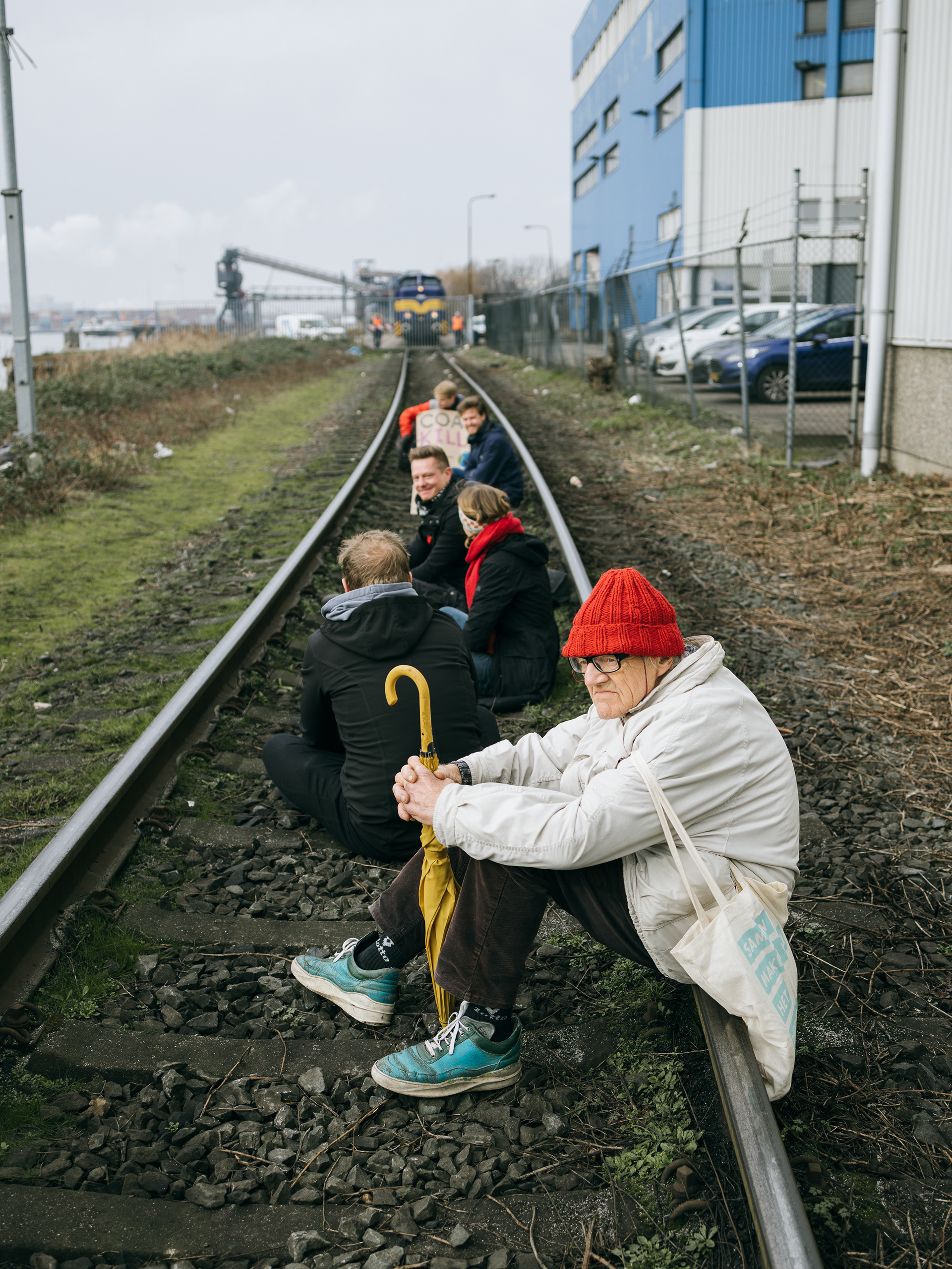 Co en zijn mede-actievoerders bezetten het spoor, met op de achtergrond de kolentrein op de HES terminal. De Amsterdamse politie heeft de actievoerder uiteindelijk (zonder geweld) van het spoor afgehaald en opgepakt.