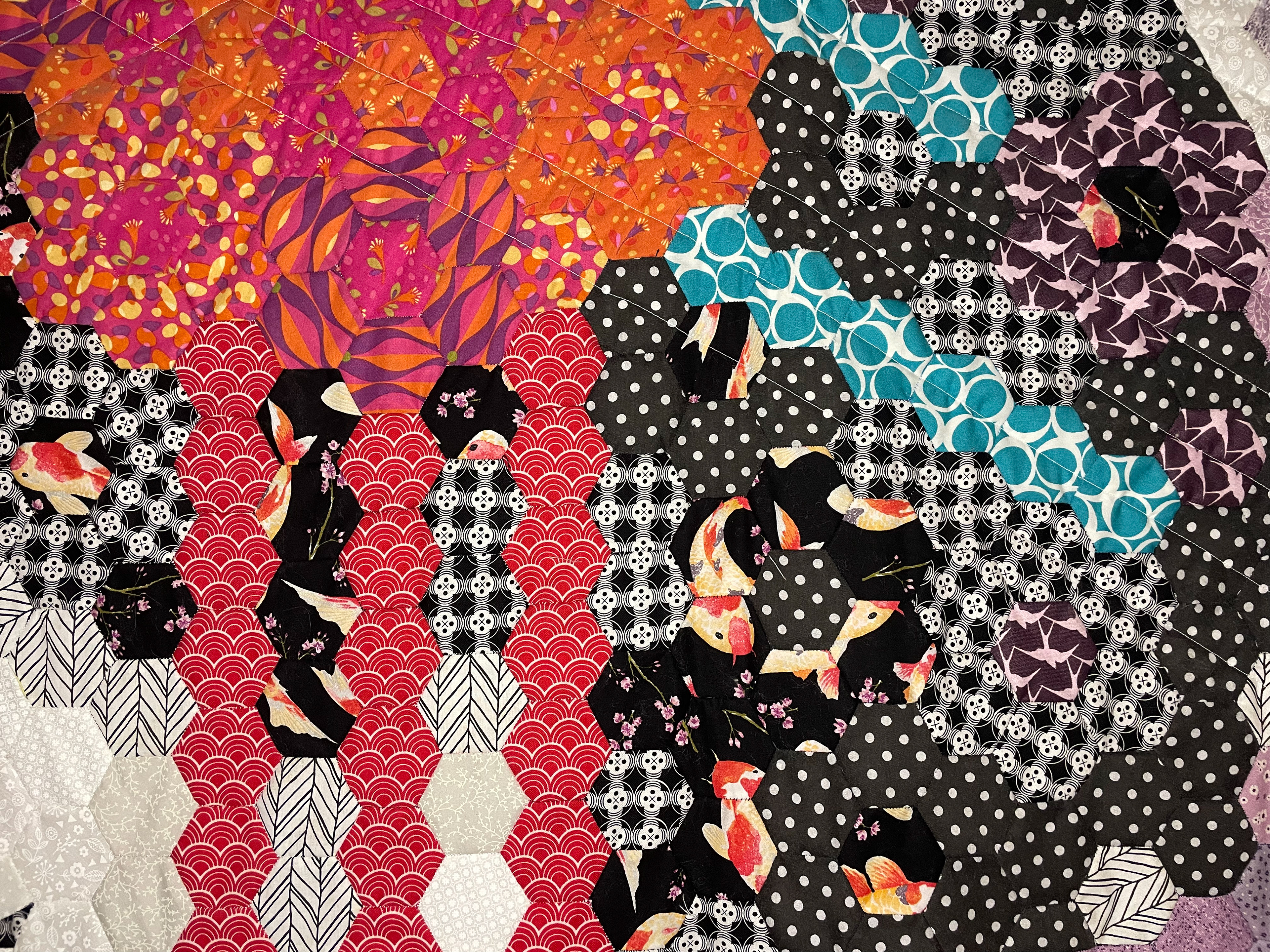 Close up of patchwork hexagons with koi carp and bold colours.